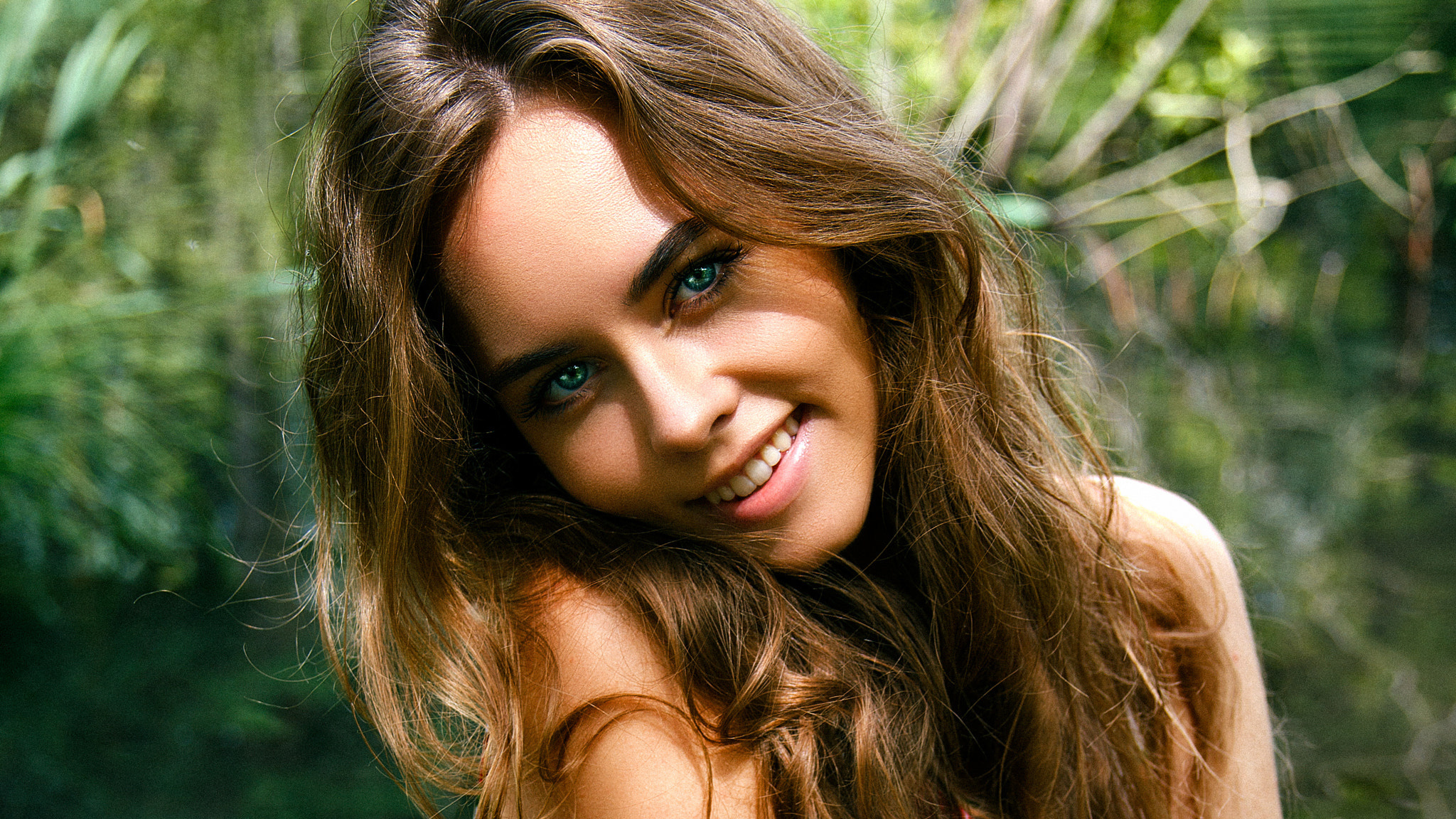 Woman with blue eyes smiling outdoors HD Wallpaper
