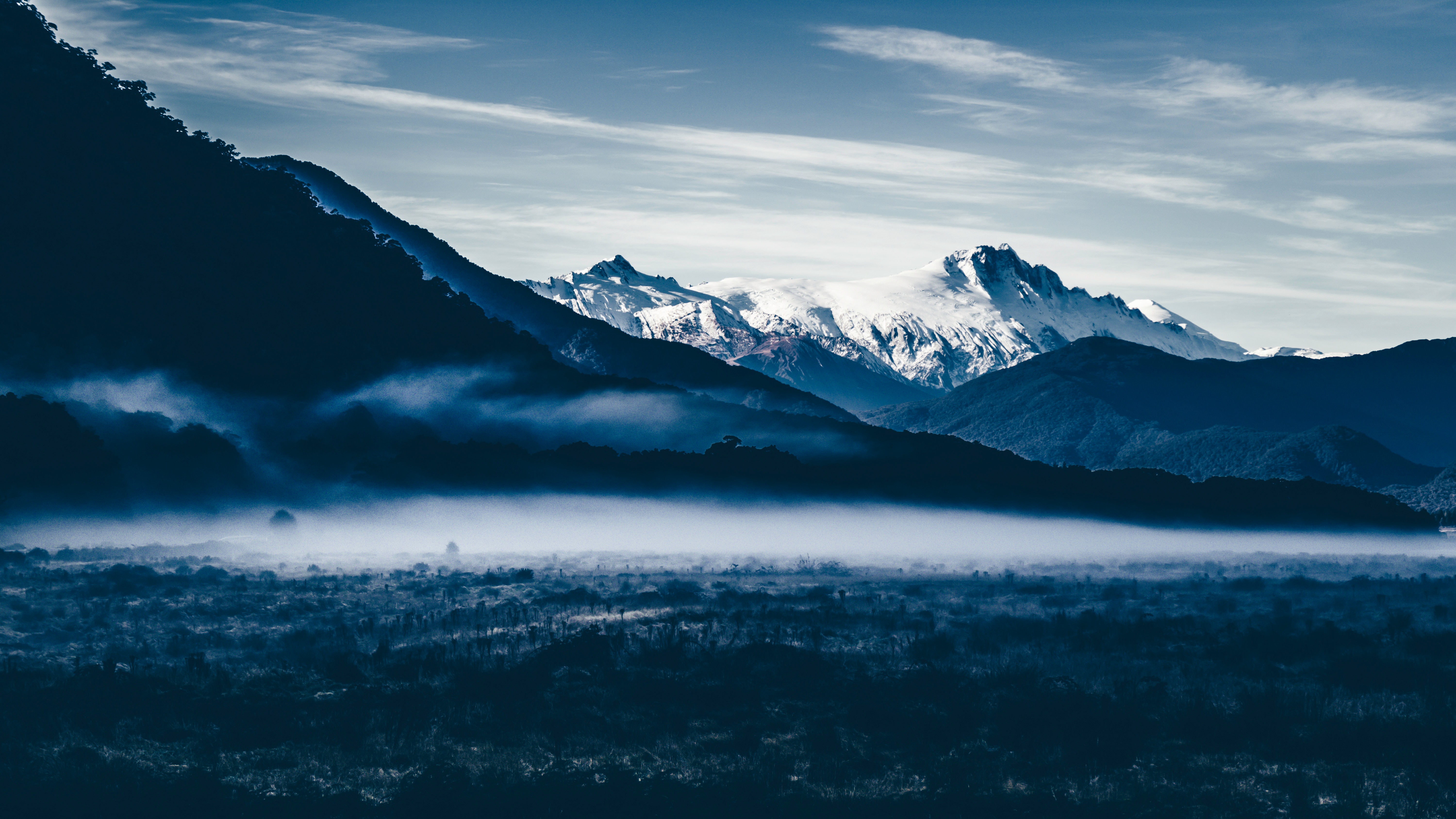Misty mountains with snow-capped peaks HD Wallpaper
