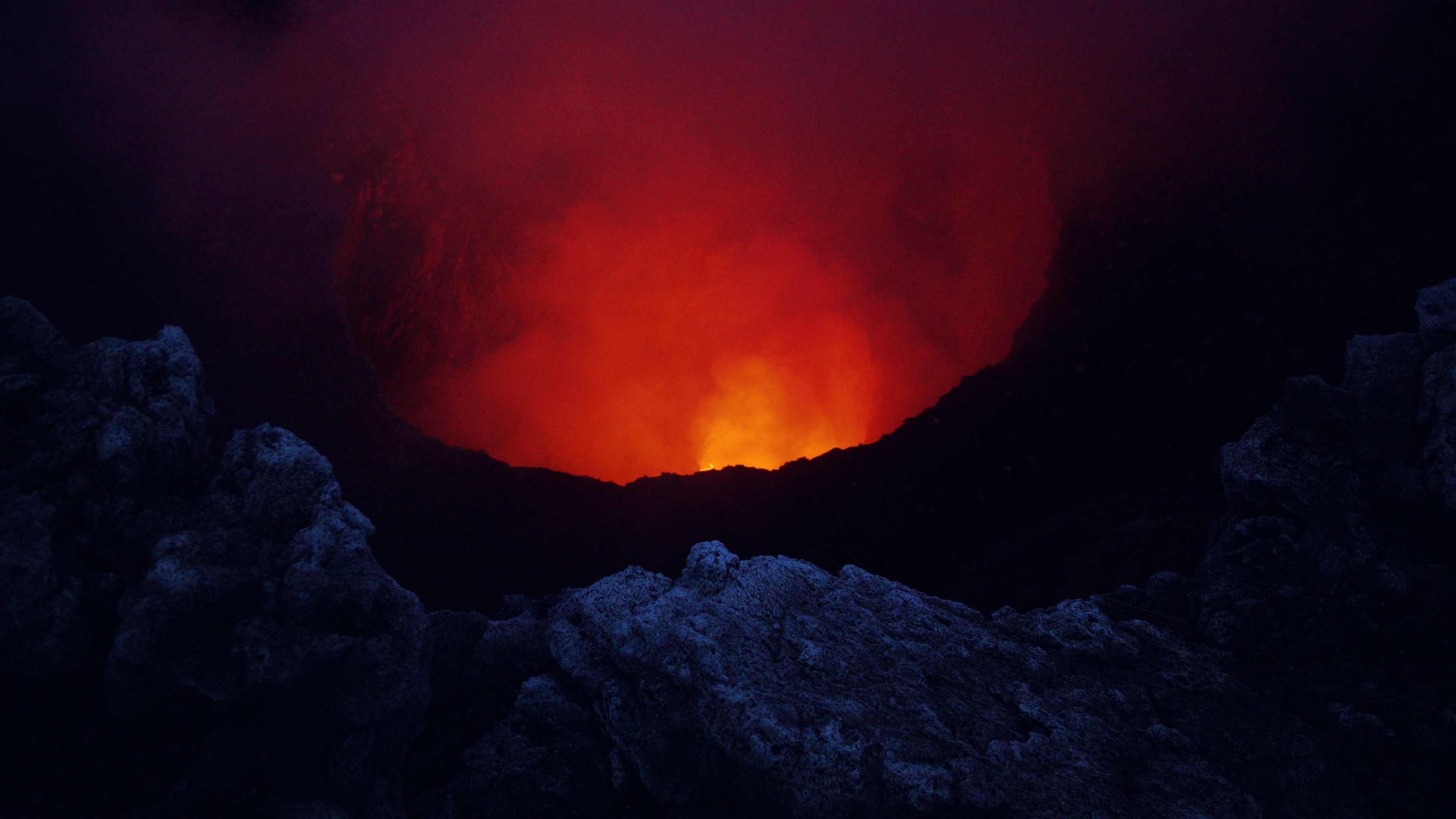 Volcanic eruption with lava and smoke in a crater HD Wallpaper
