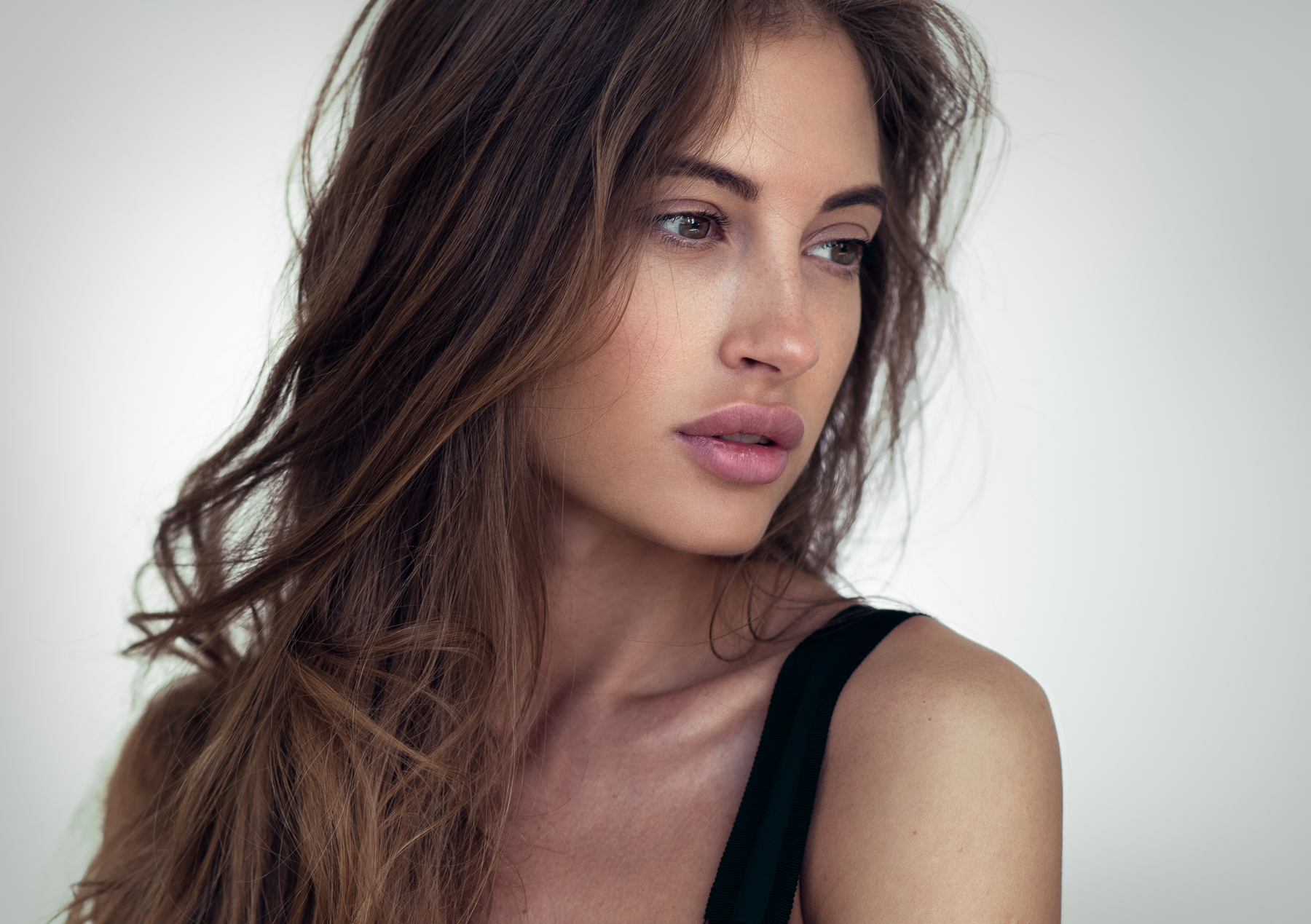 Woman with long brown hair looking away HD Wallpaper