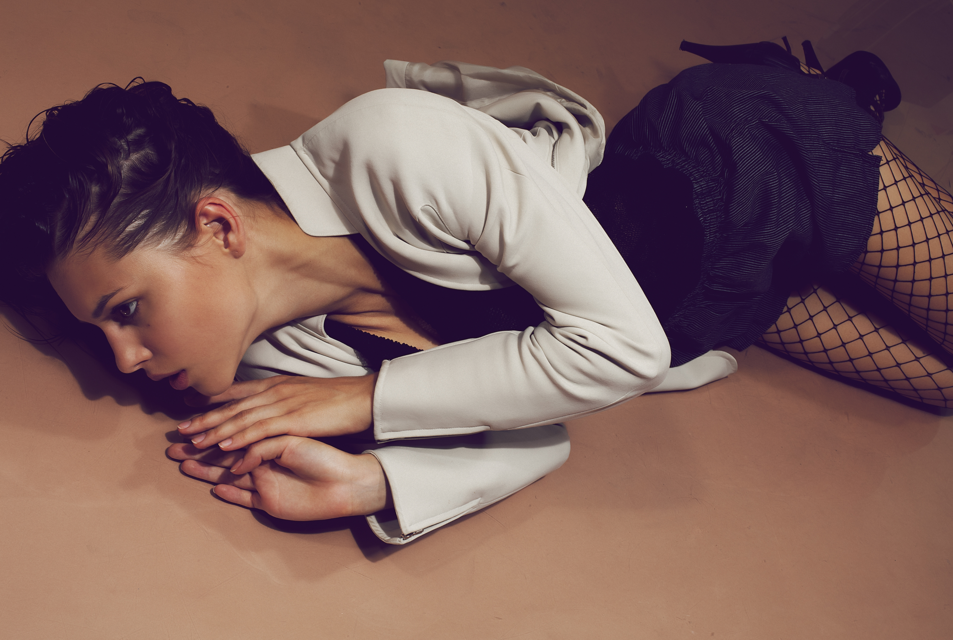 Woman in white jacket and fishnet stockings lying down HD Wallpaper