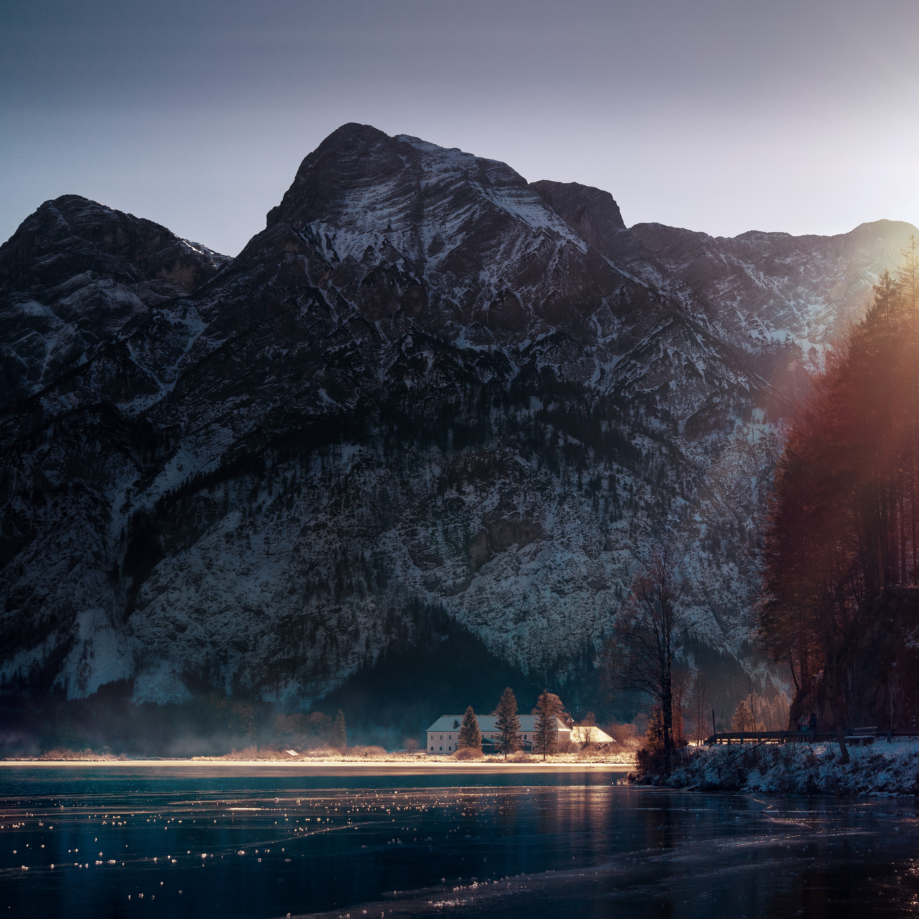 Snowy mountains and a house by a frozen lake HD Wallpaper
