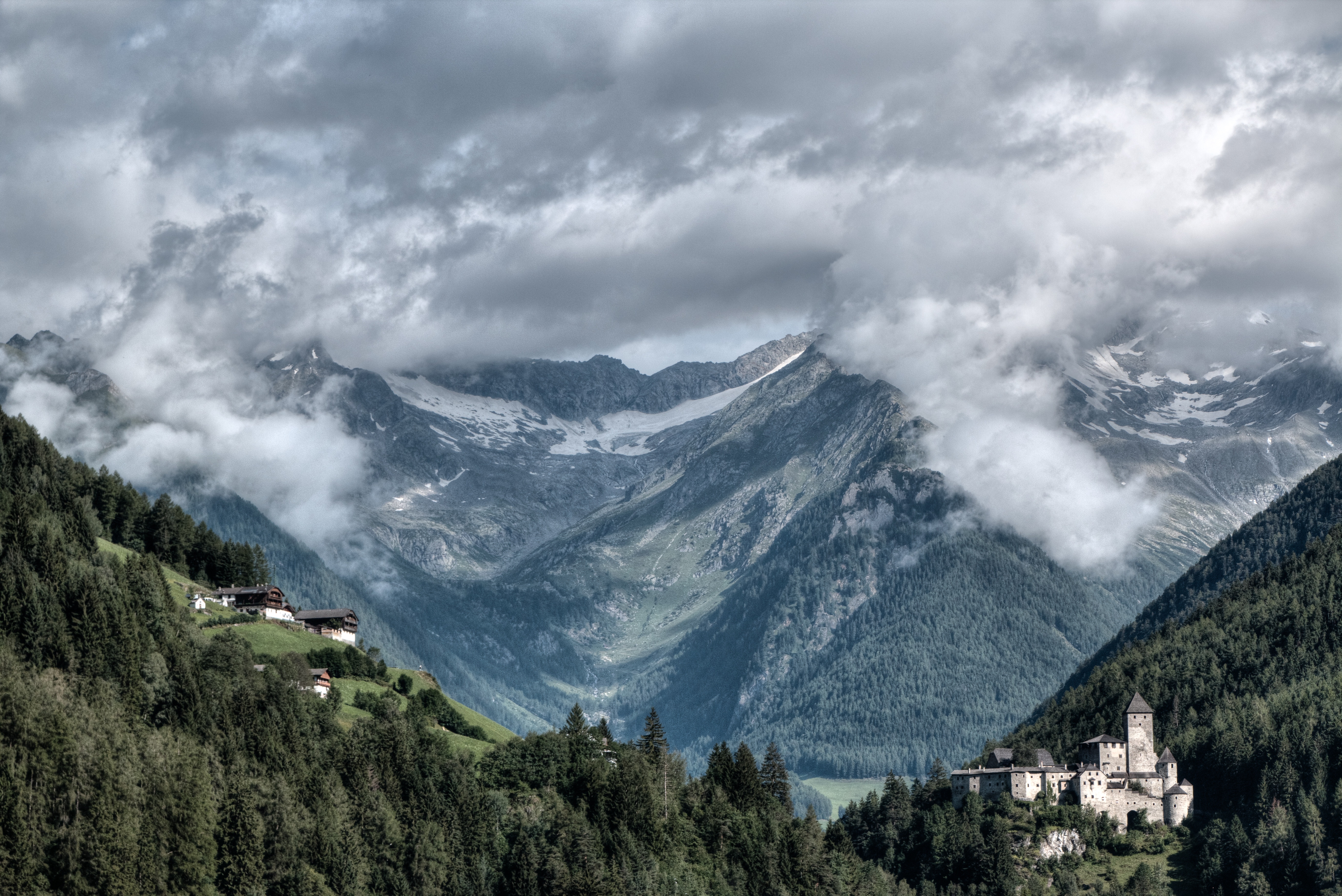 Castle and houses in a mountain valley with clouds HD Wallpaper