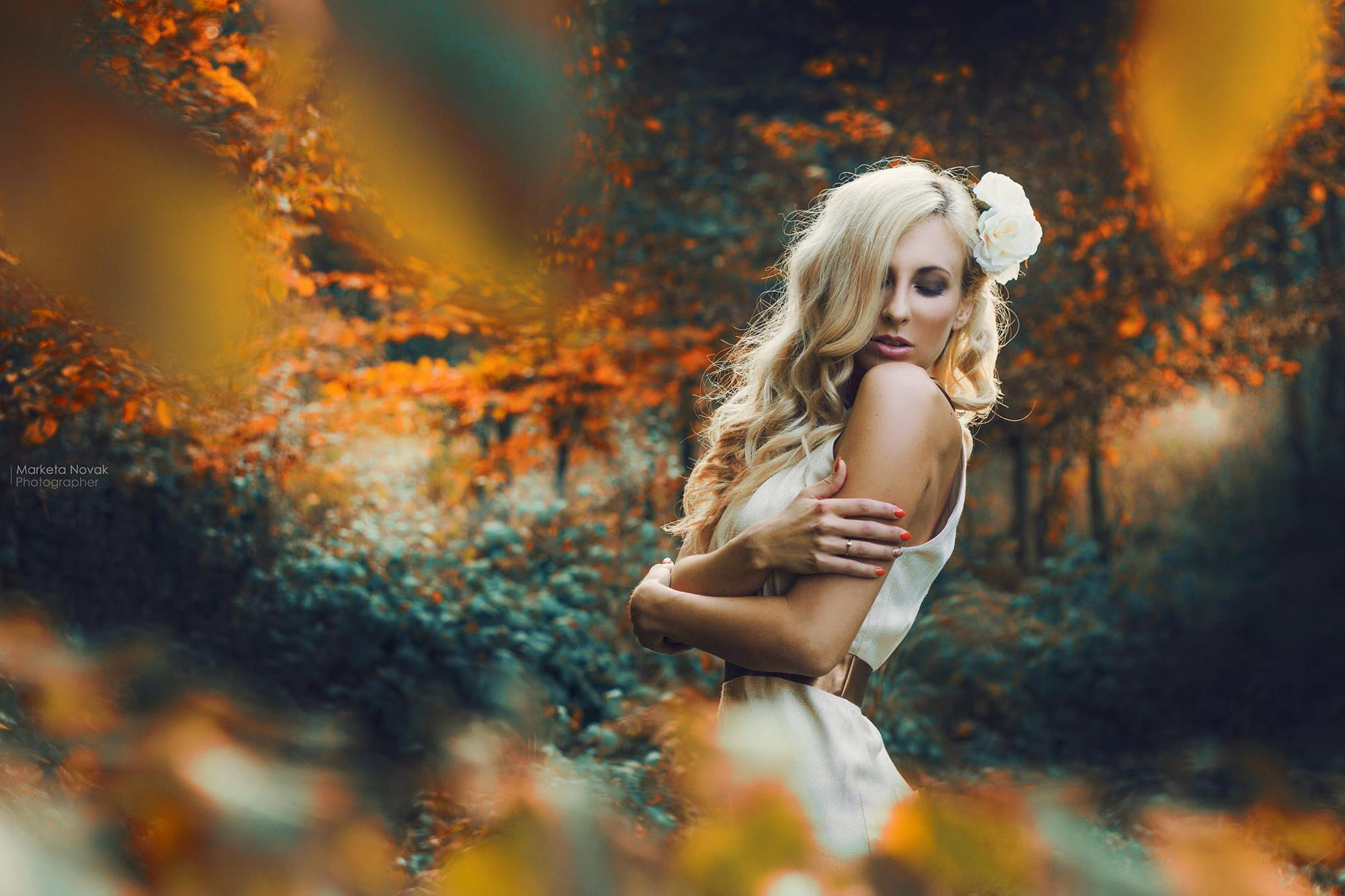 Woman with blonde hair and a white flower in a fall forest HD Wallpaper
