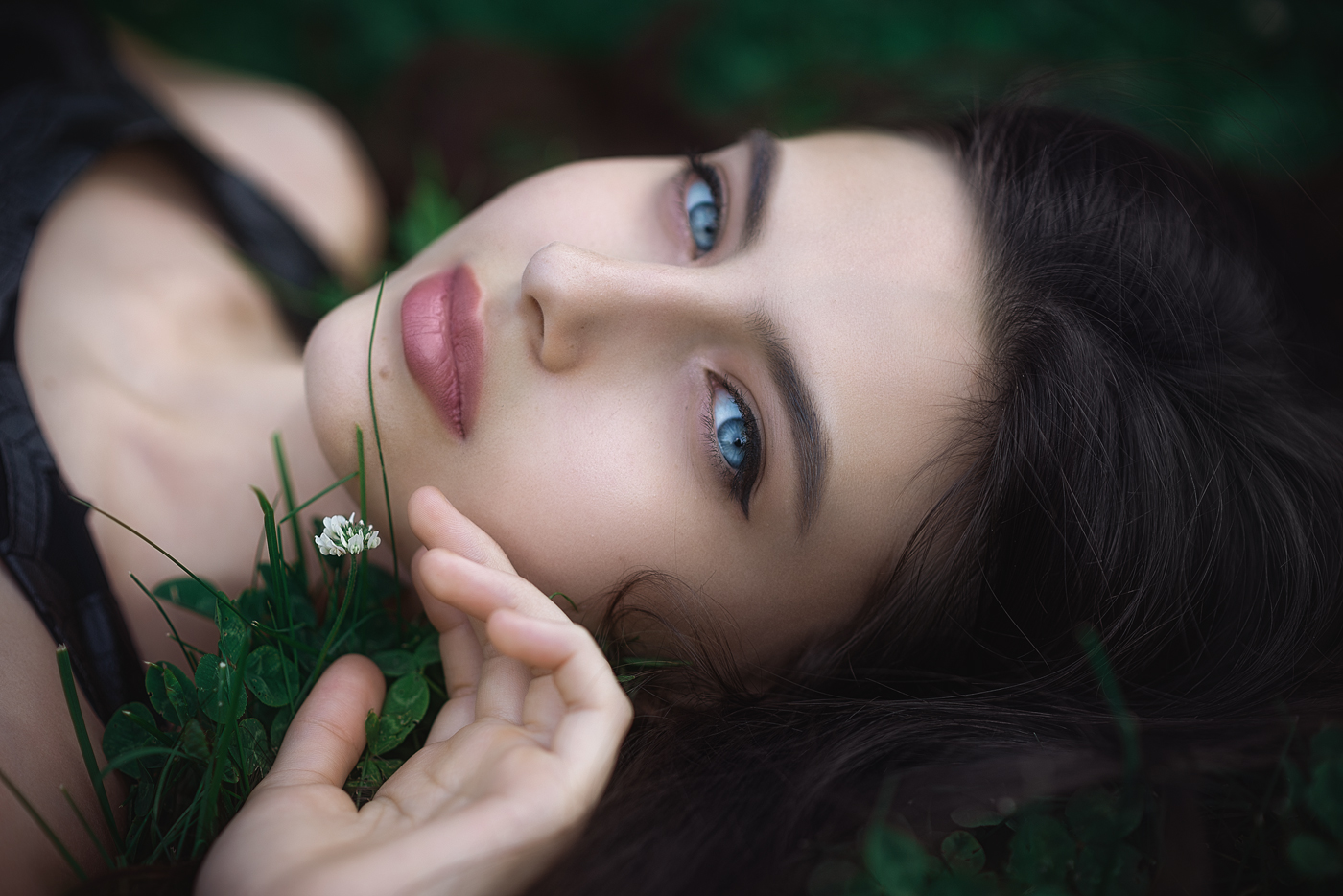 Woman with blue eyes lying in grass HD Wallpaper