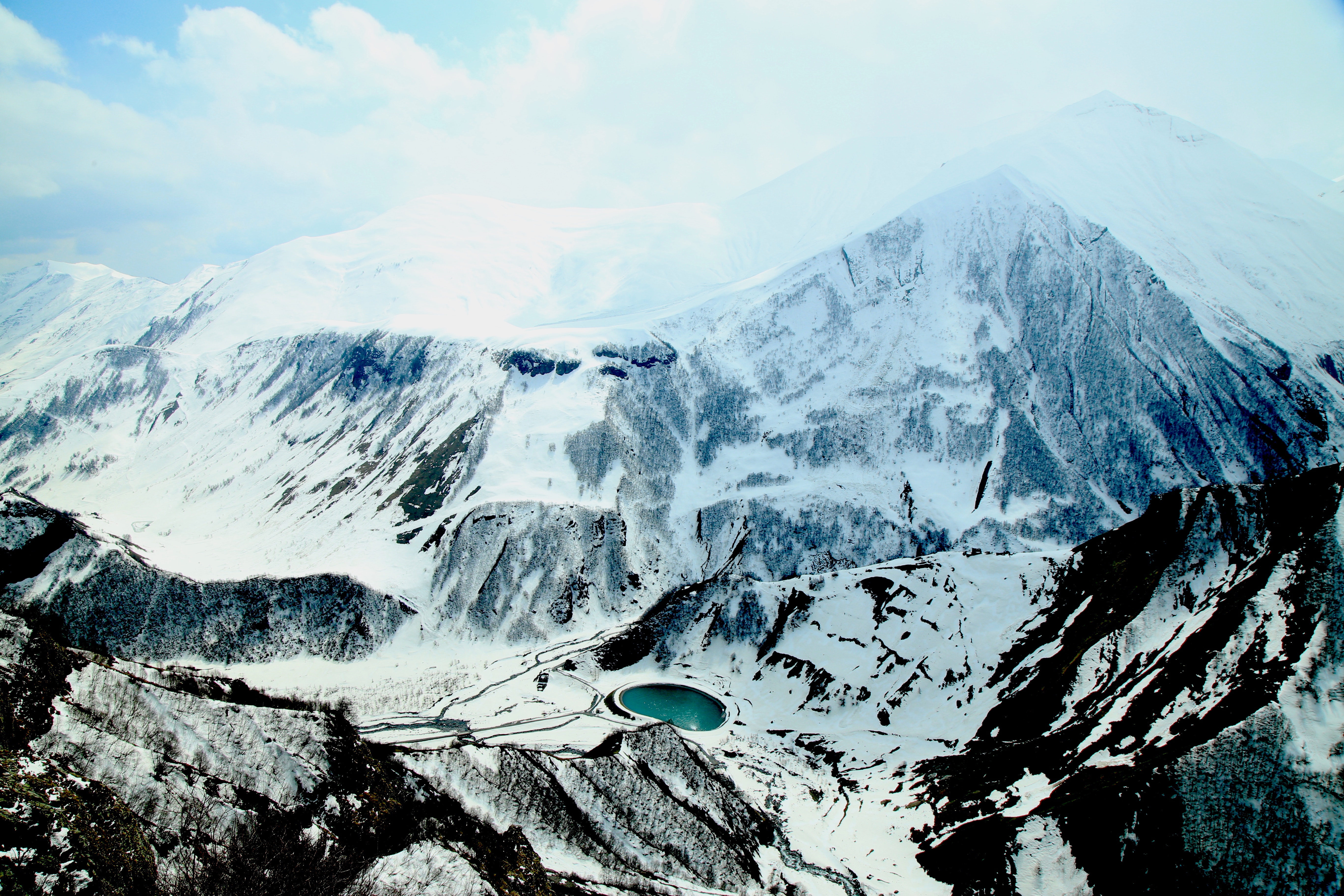 Snowy mountains with a turquoise lake HD Wallpaper