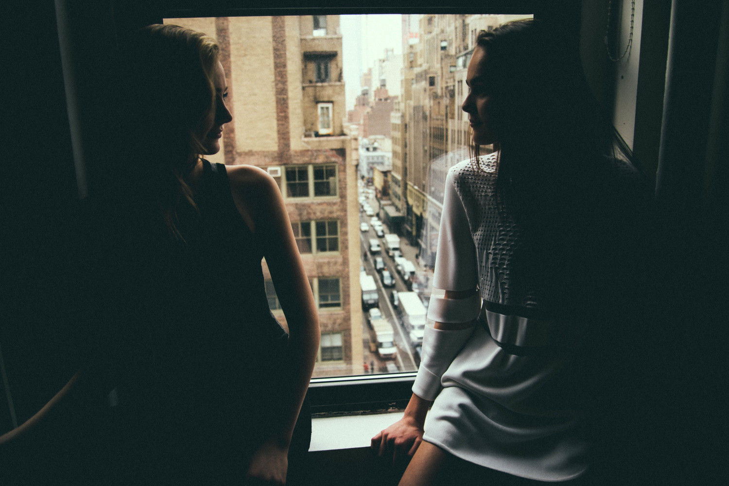 Women looking out window in New York City HD Wallpaper