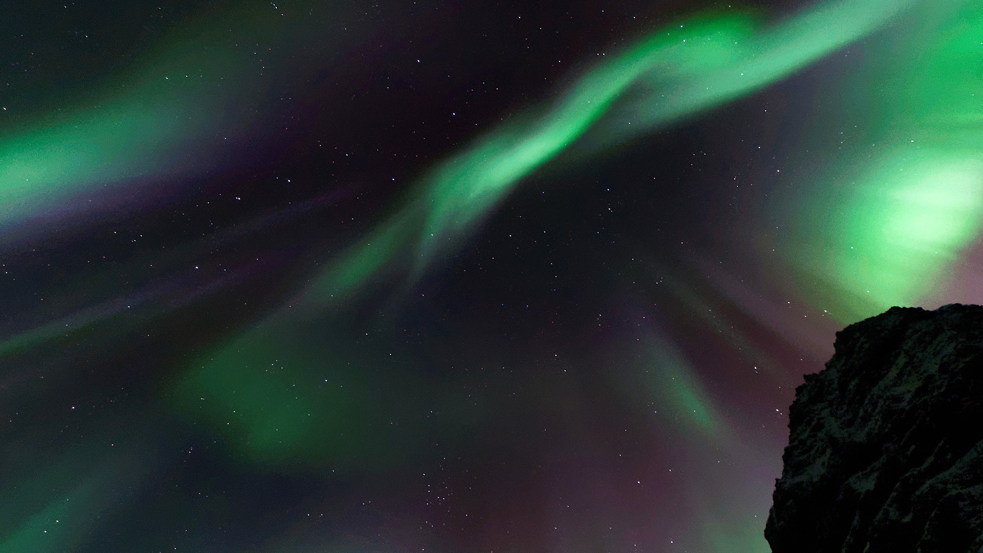 Aurora Borealis over rocky terrain HD Wallpaper