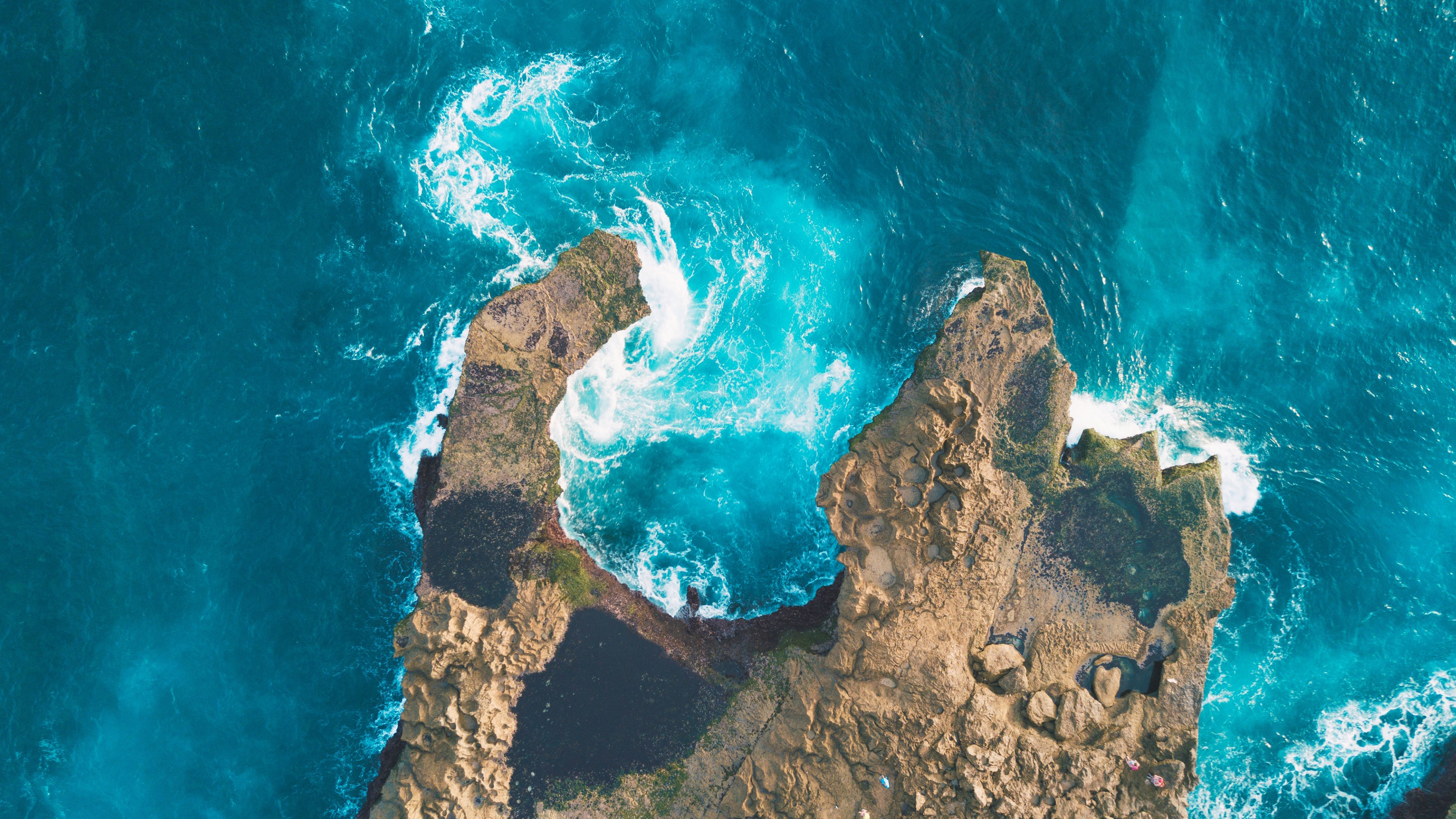 Aerial view of rocky coast with turquoise ocean waves HD Wallpaper