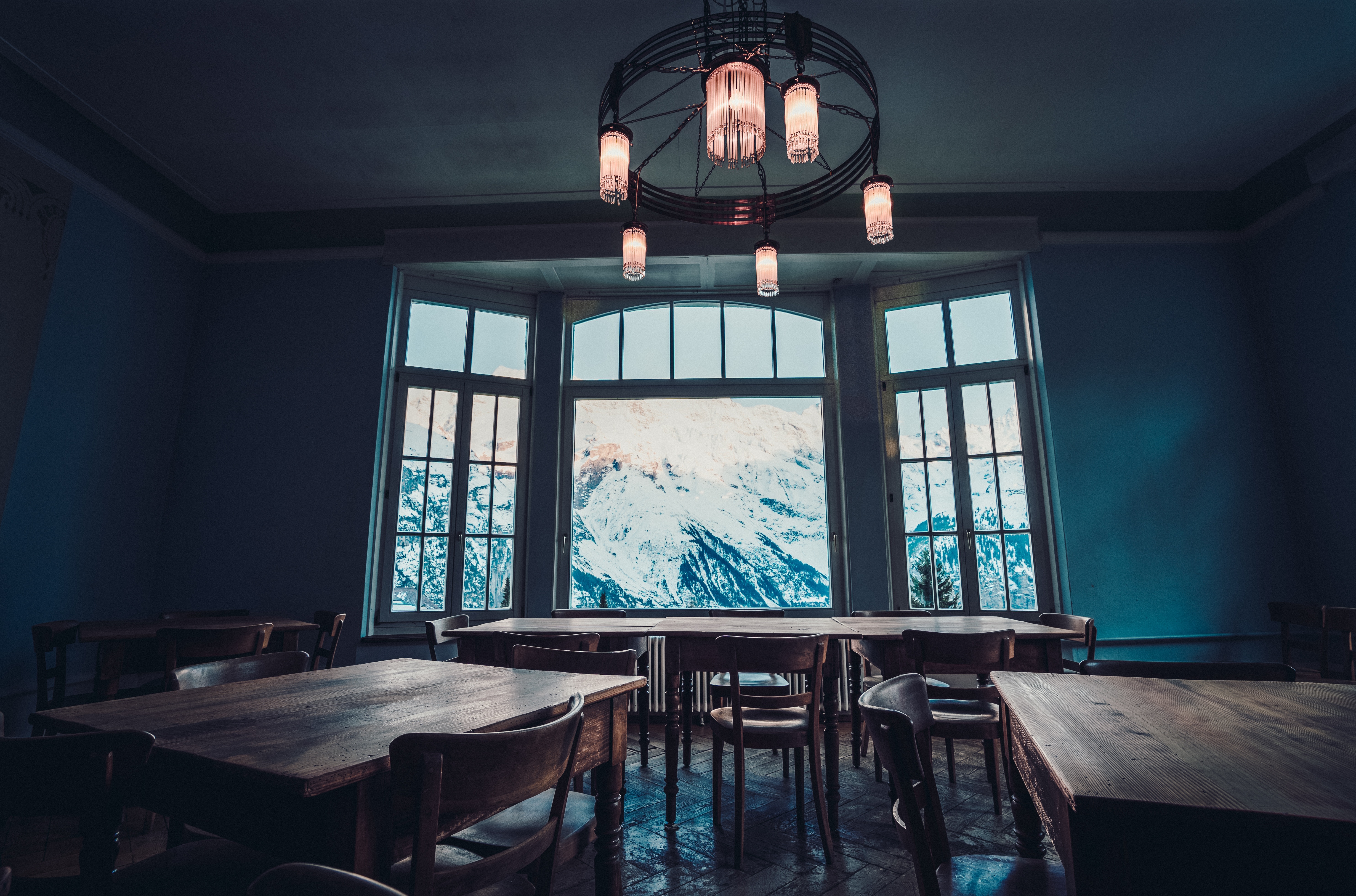 Dining room with large window overlooking snowy mountains HD Wallpaper