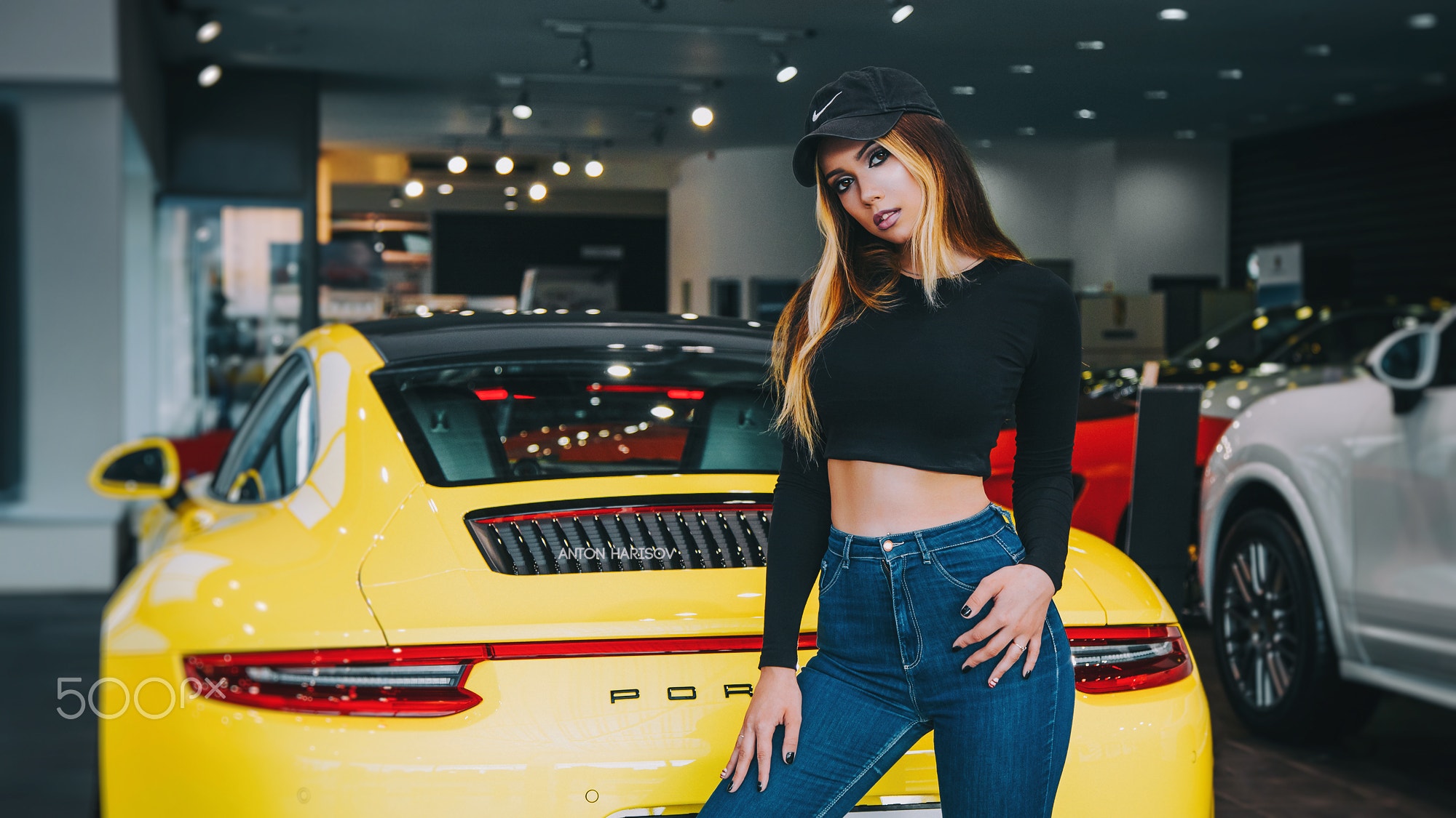 Woman in black crop top and jeans posing by yellow Porsche HD Wallpaper