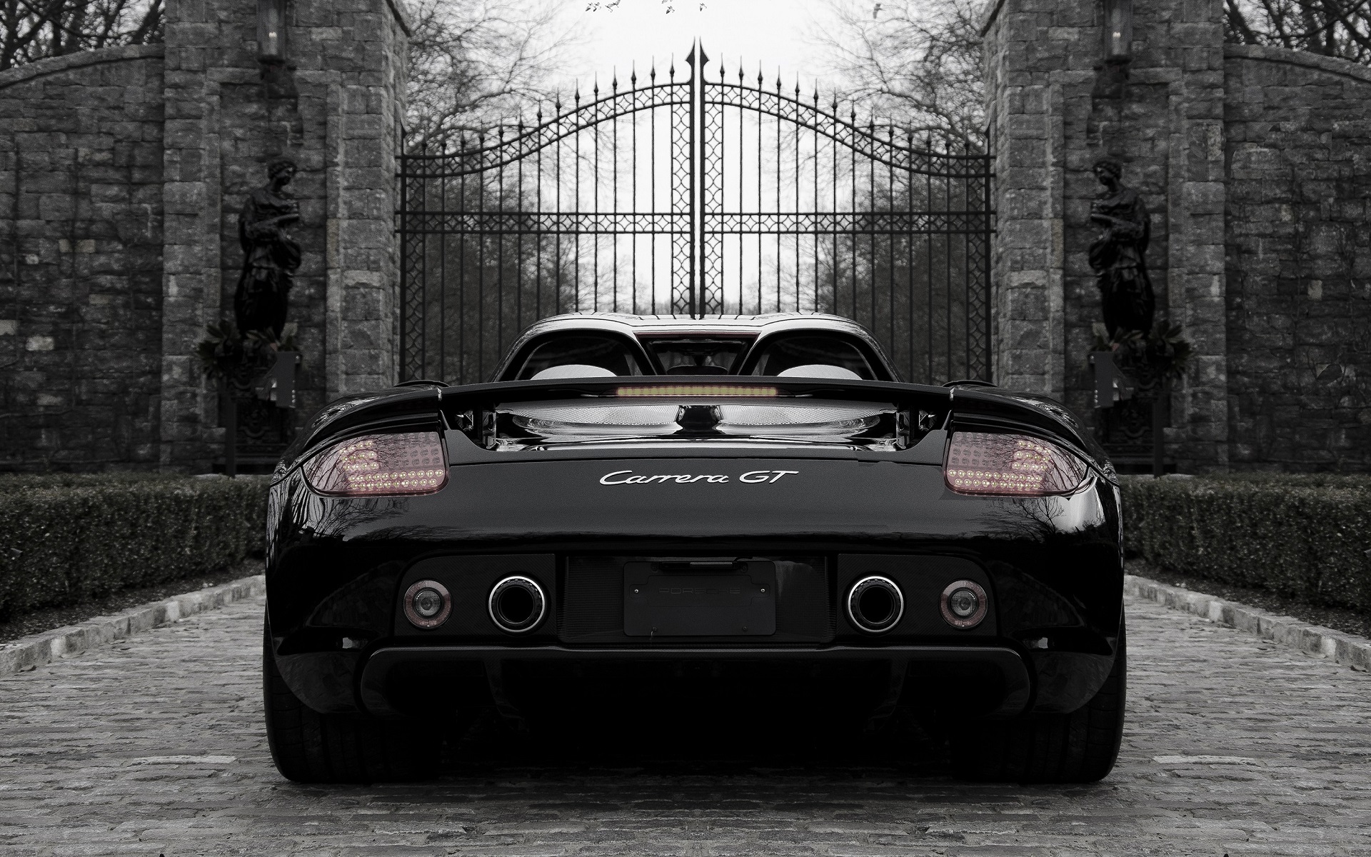Black Porsche Carrera GT in front of a gate HD Wallpaper