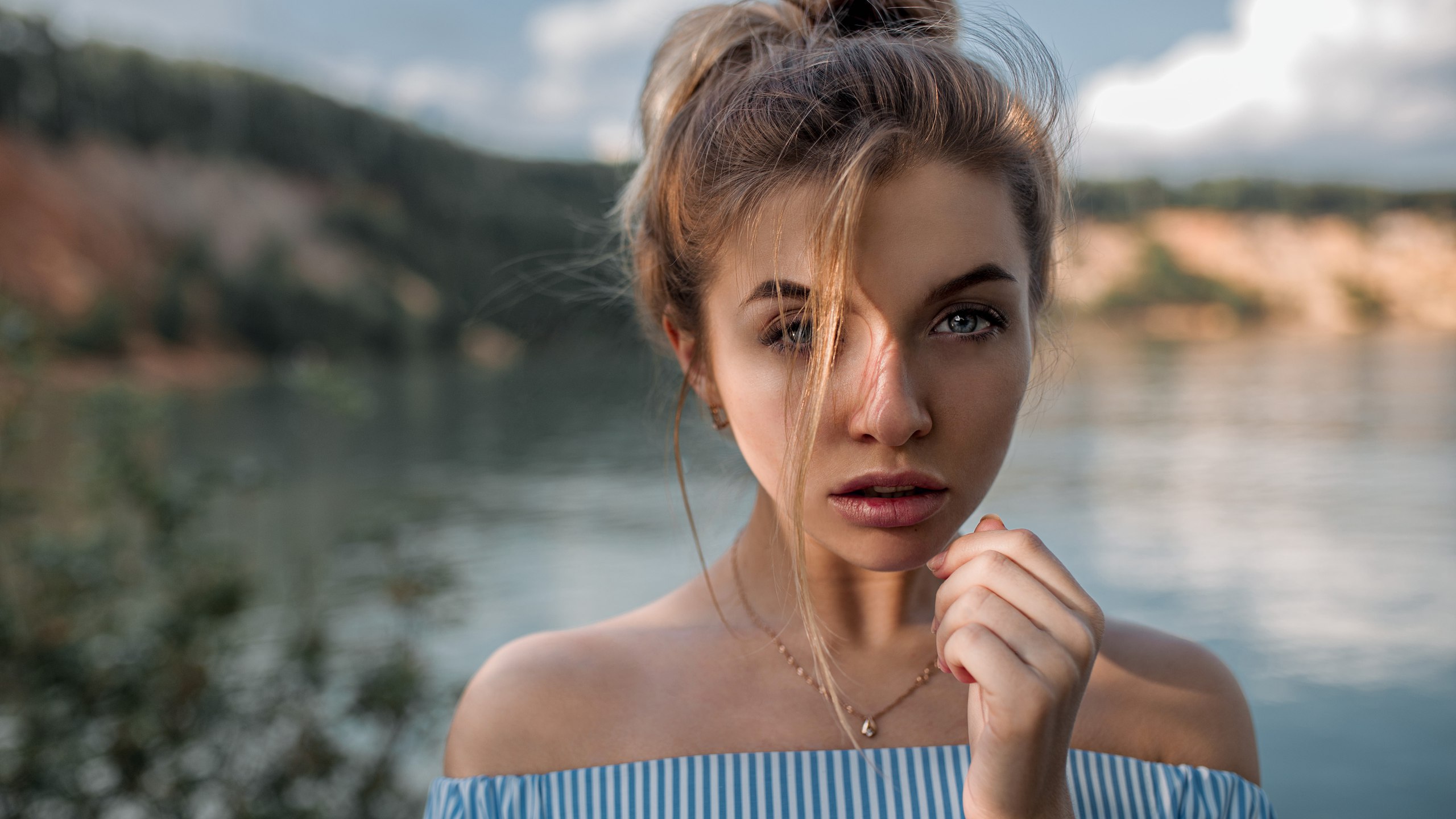 Woman with hair in face and blue eyes outdoors HD Wallpaper