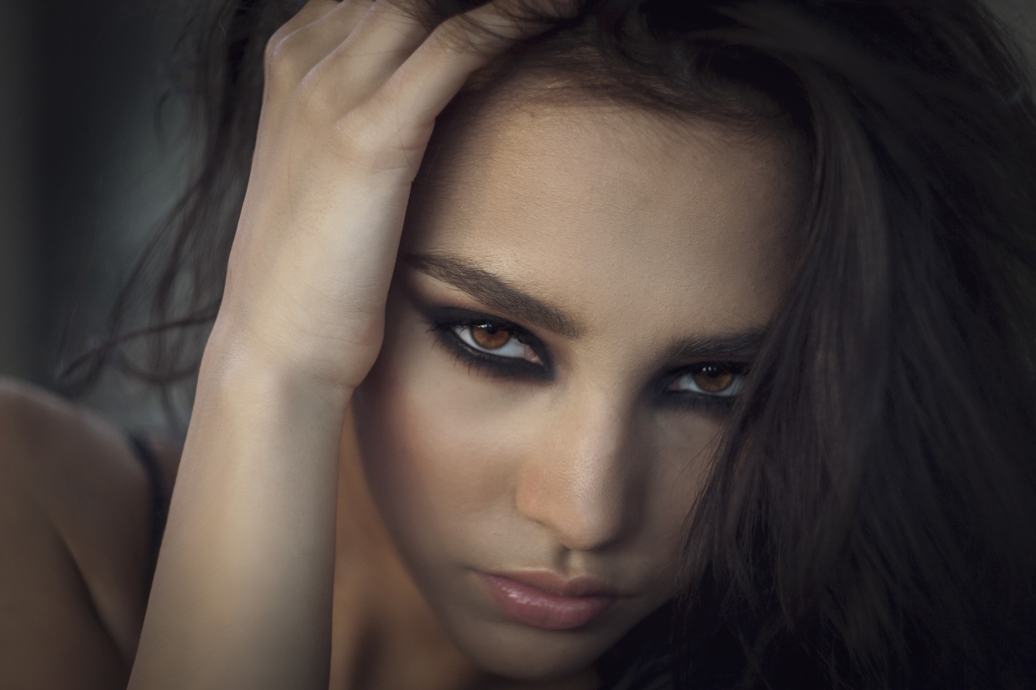 Woman with dark hair and smoky eye makeup HD Wallpaper