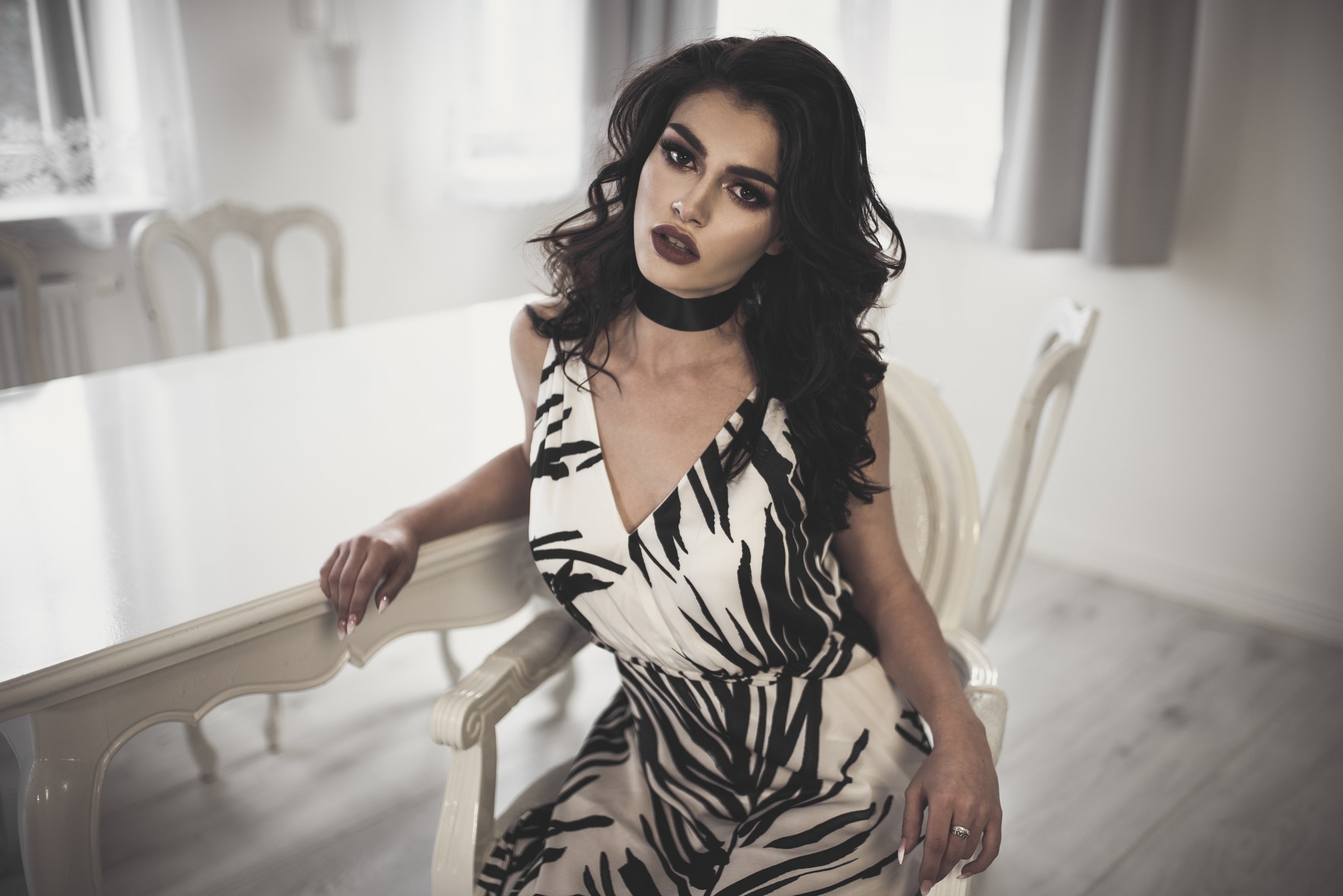 Woman wearing a choker and dress sitting at a table HD Wallpaper