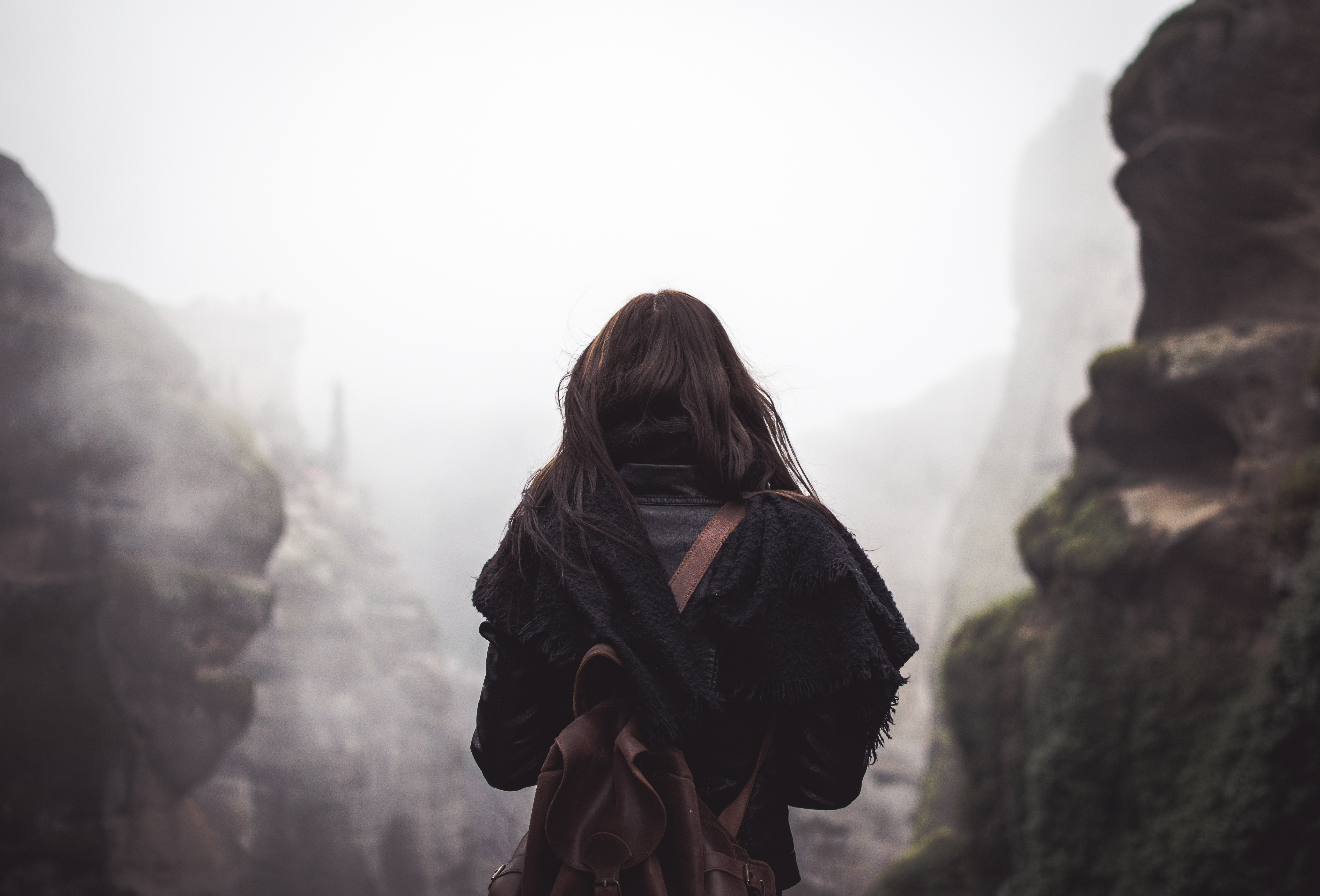 Woman with backpack in foggy mountains HD Wallpaper