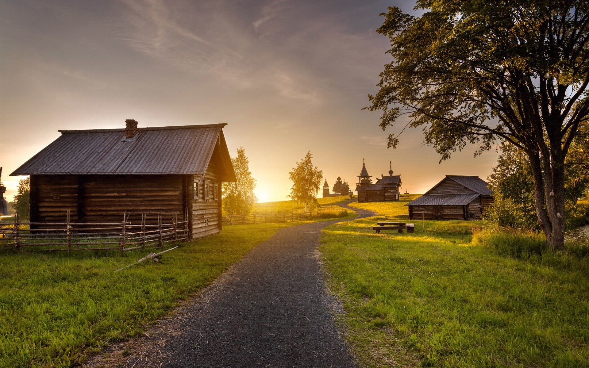 Wooden houses and churches in a rural landscape at sunset HD Wallpaper