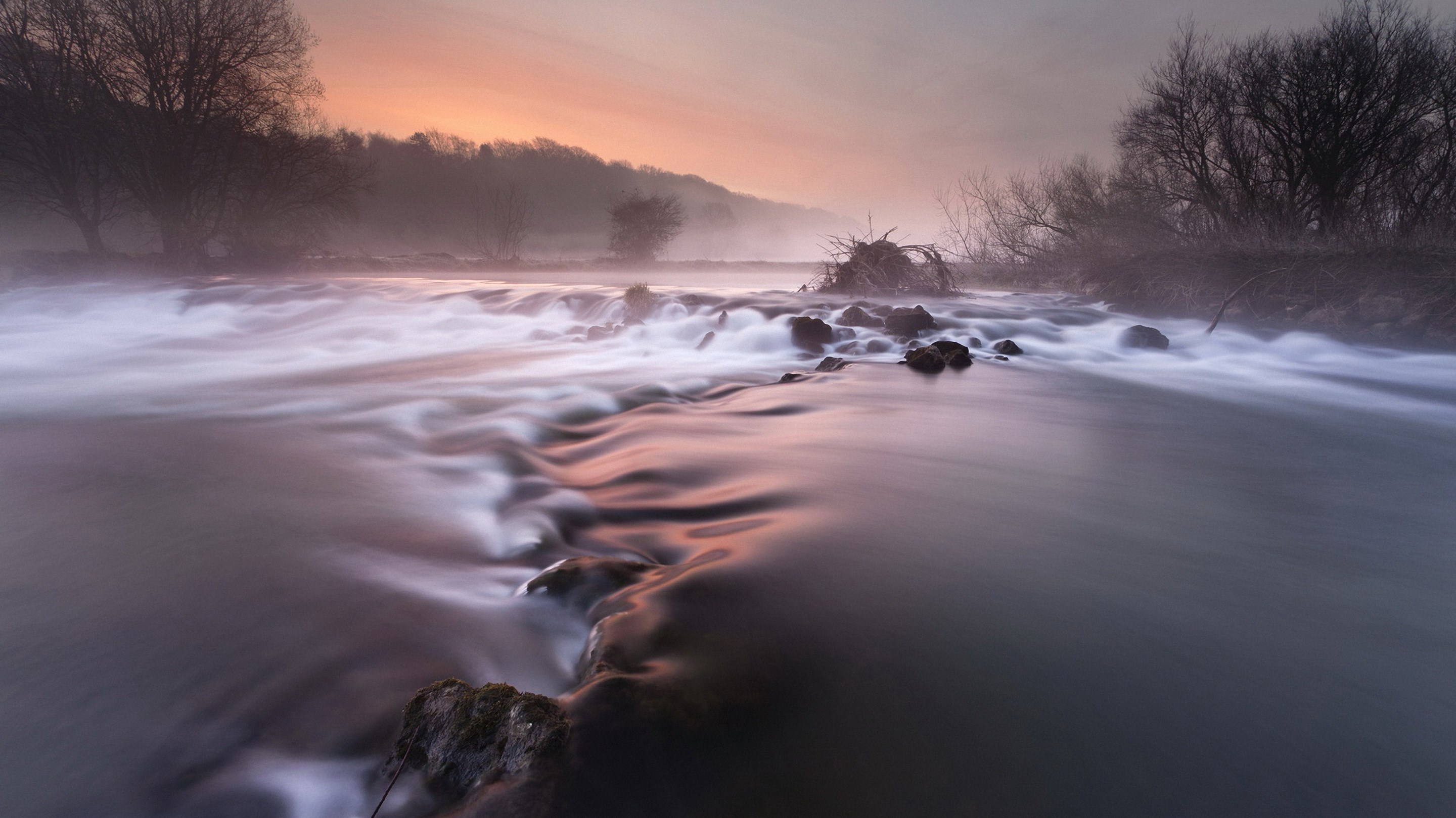 Misty river at sunrise with trees and rocks HD Wallpaper