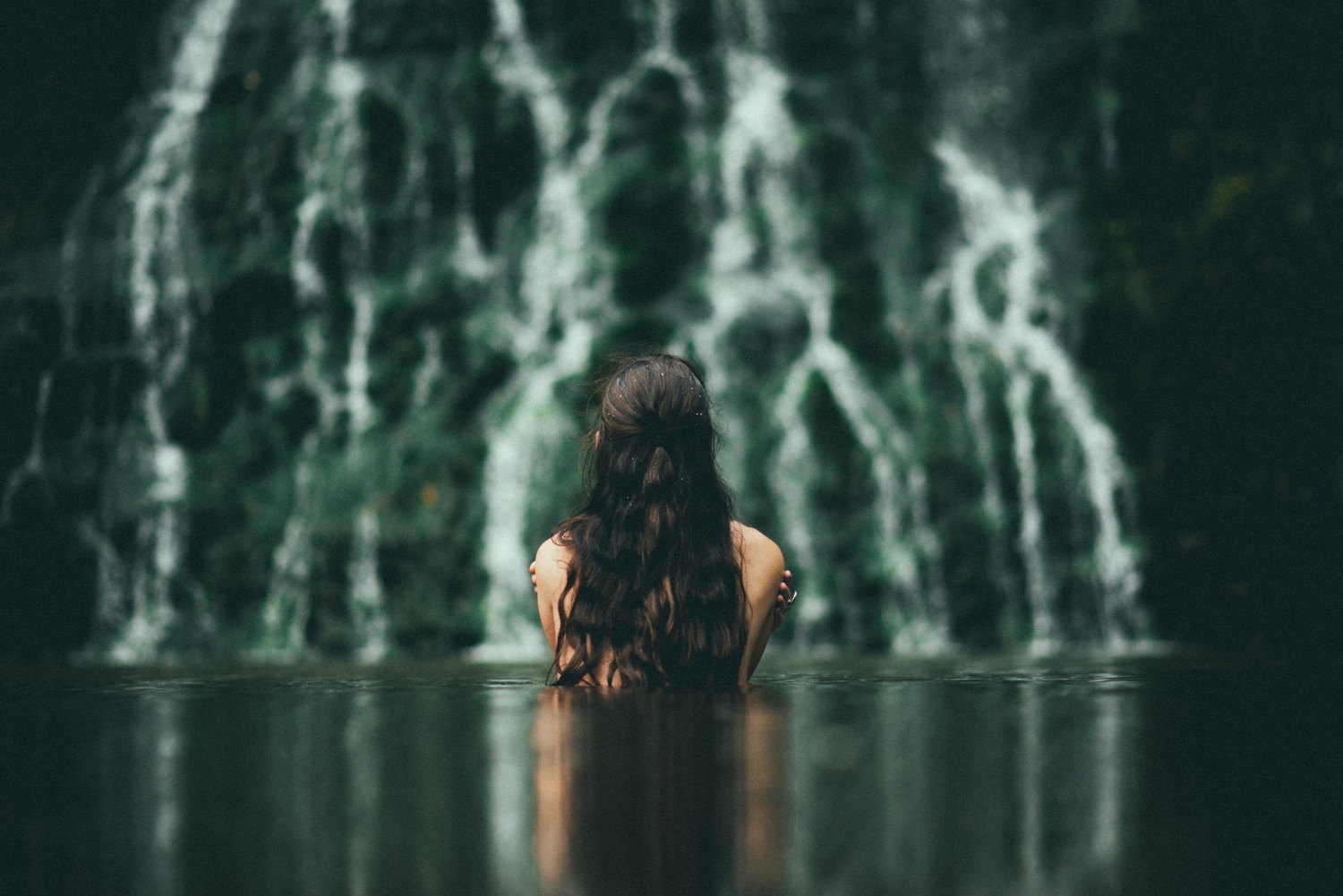 Woman bathing in a river in front of a waterfall HD Wallpaper