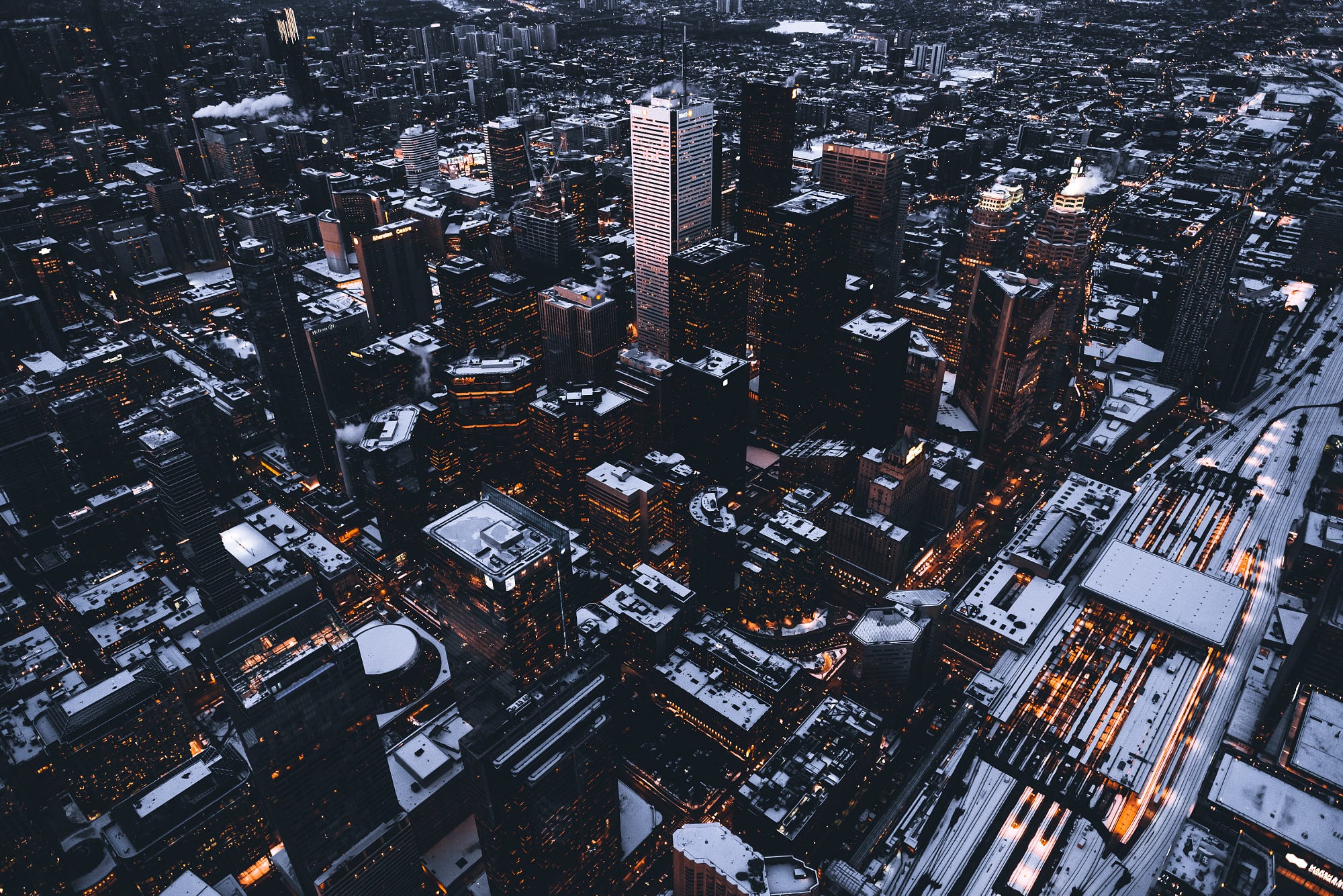 Aerial view of a snowy cityscape at night HD Wallpaper