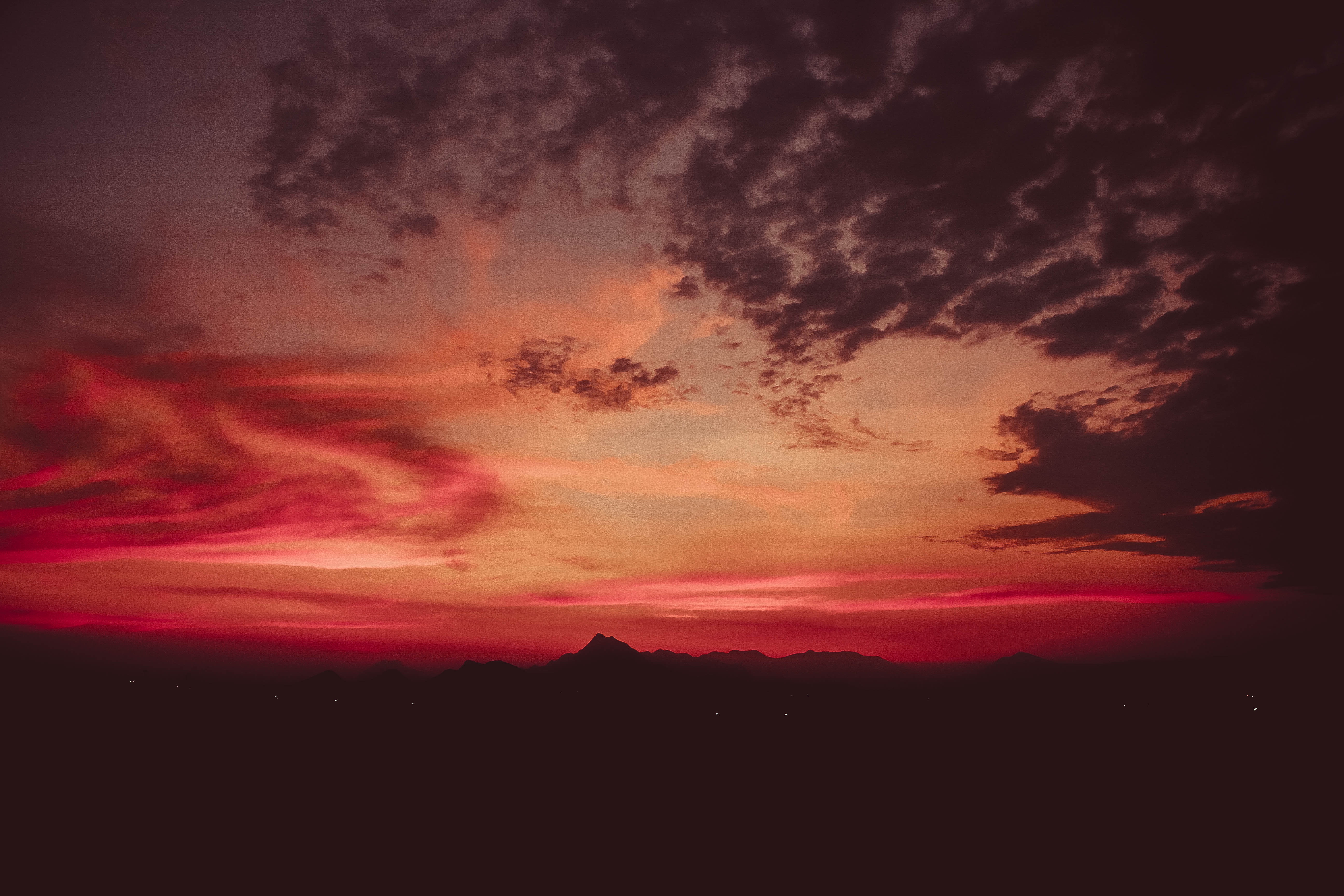 Dramatic sunset over silhouetted mountains HD Wallpaper
