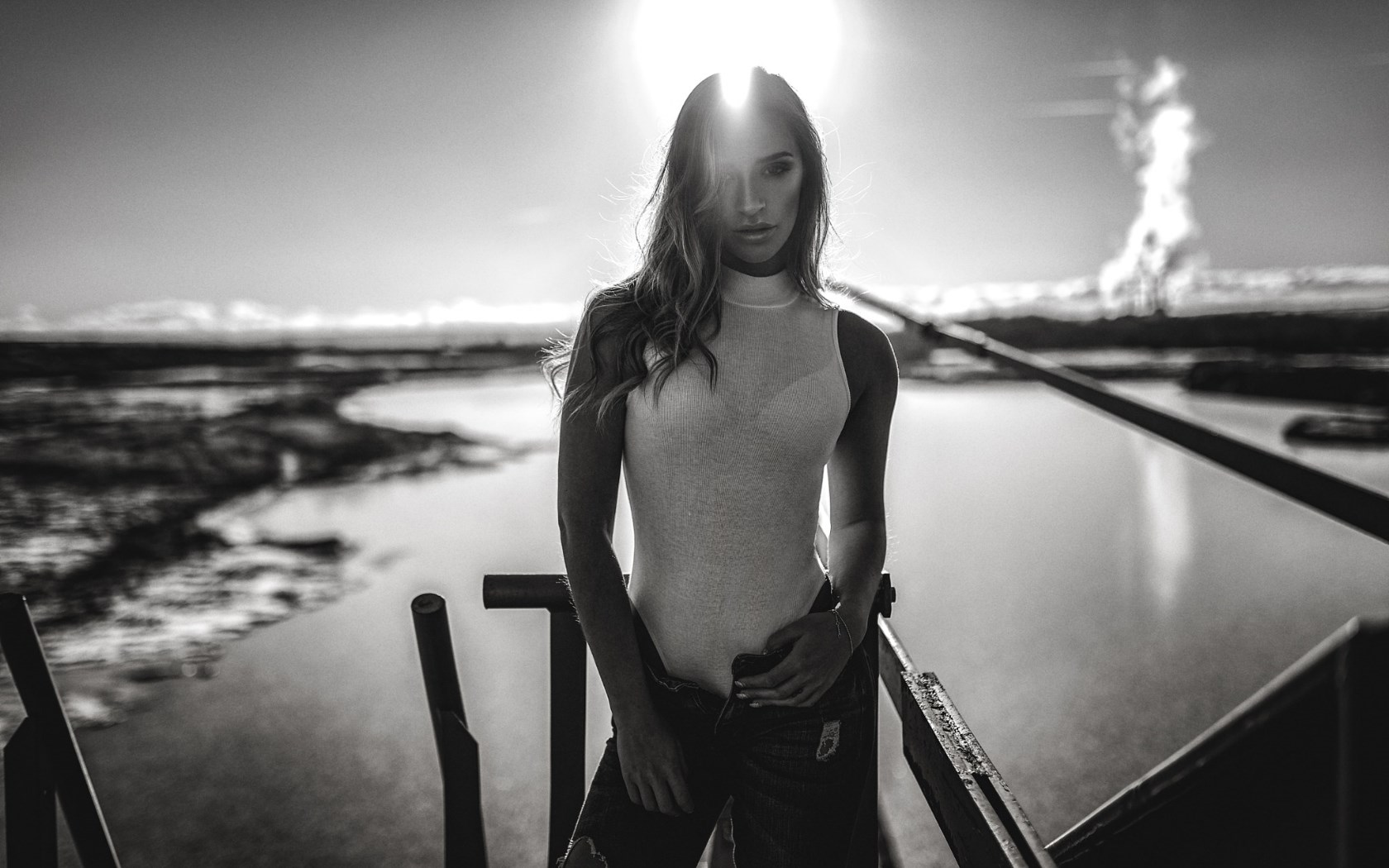 Woman in bodysuit and jeans posing by water HD Wallpaper
