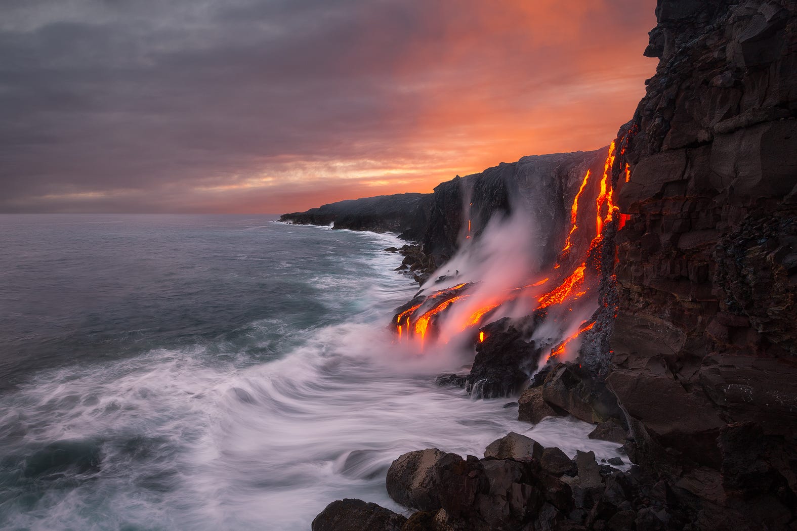 Lava flowing into the ocean at sunset in Hawaii HD Wallpaper