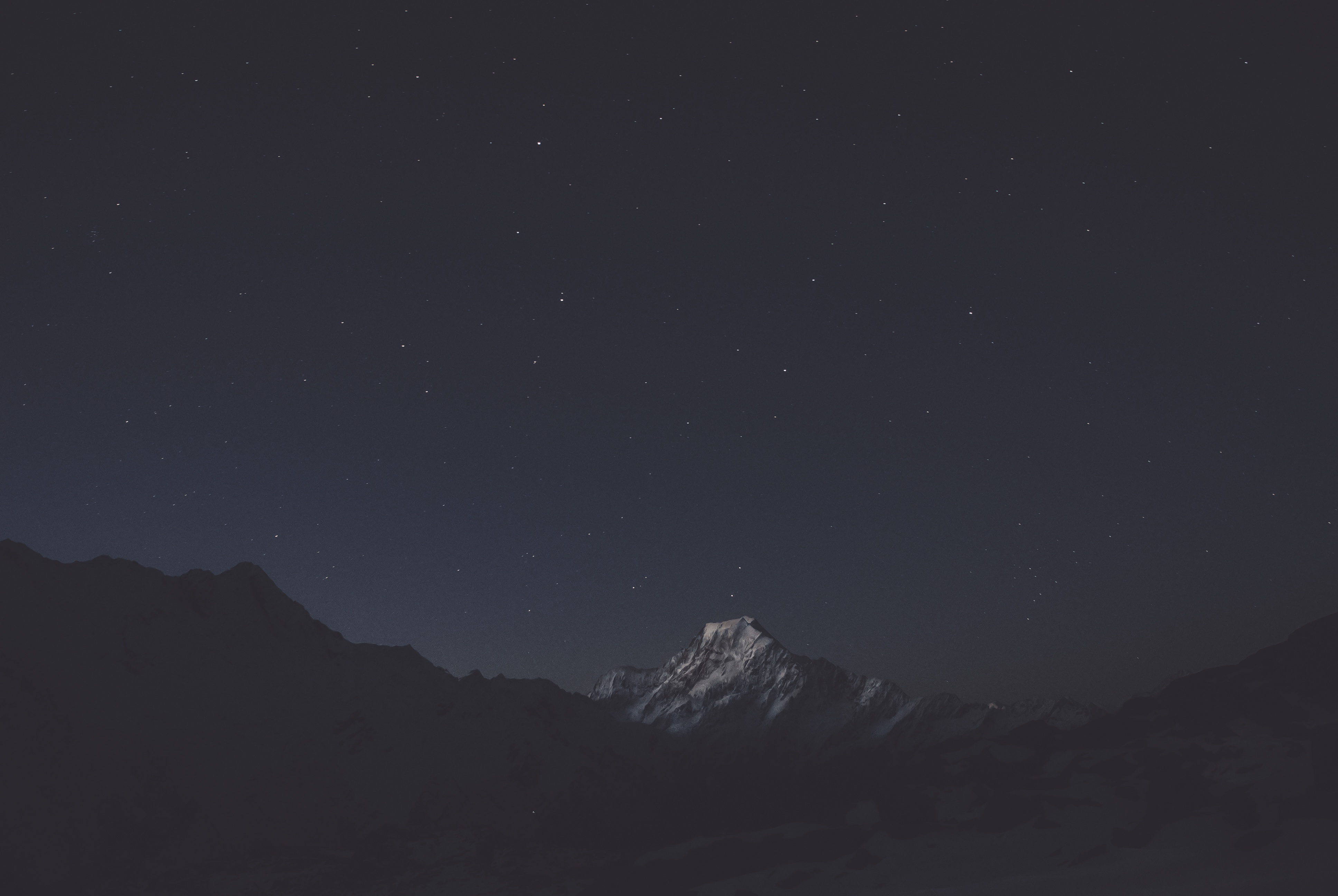 Snow-capped mountain under a starry night sky HD Wallpaper