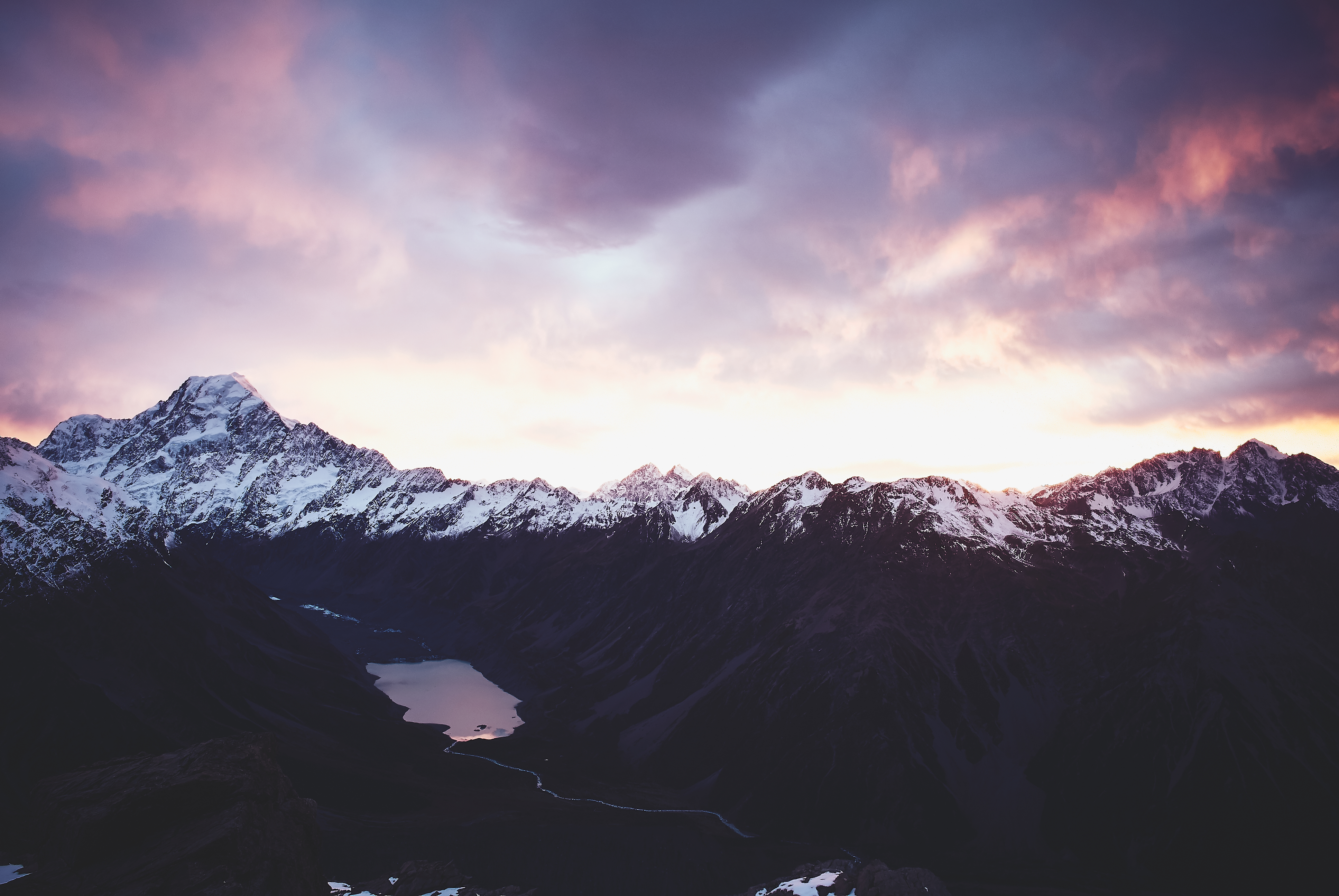 Snow-capped mountains and a lake at sunset HD Wallpaper