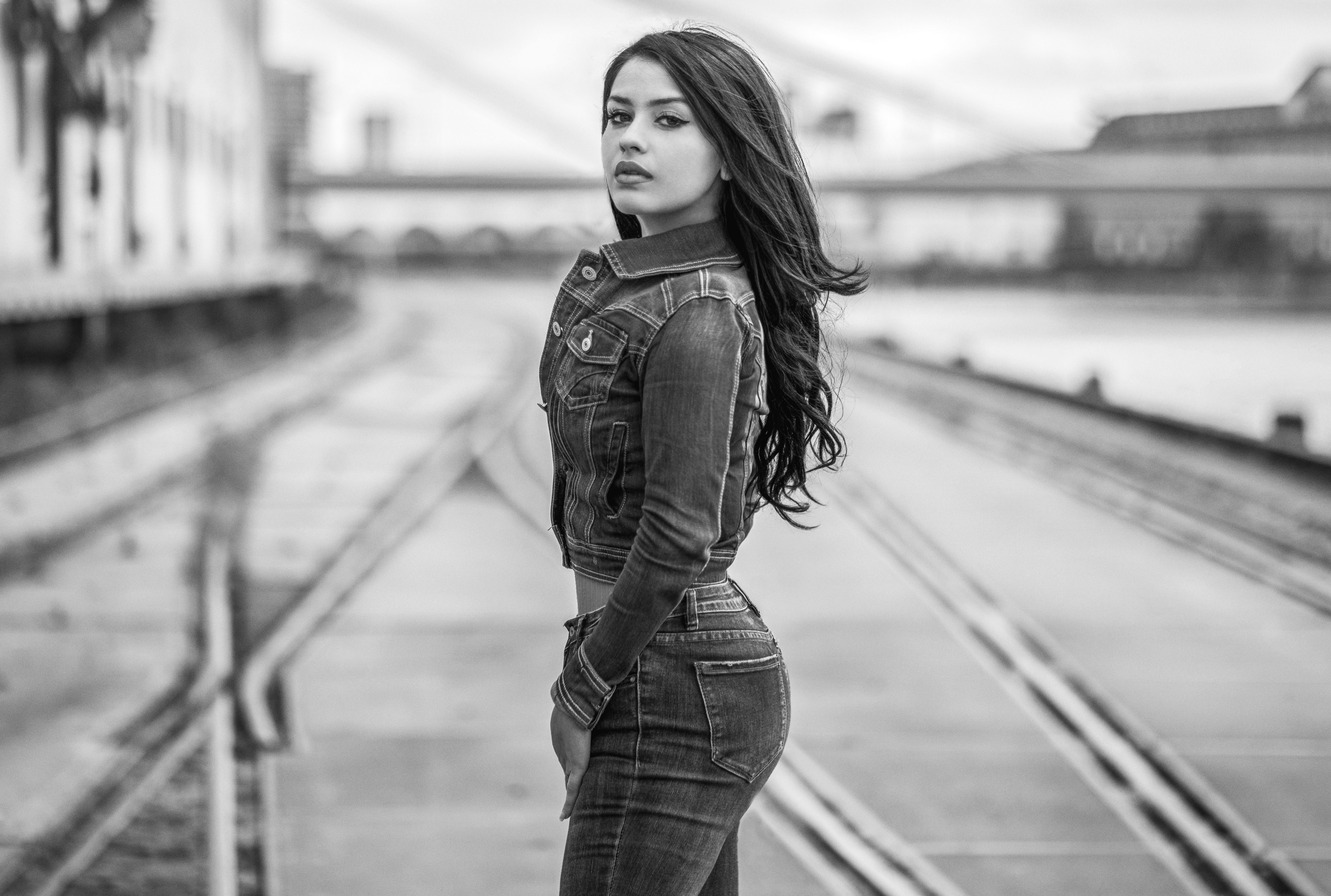 Woman in denim outfit on railway tracks HD Wallpaper