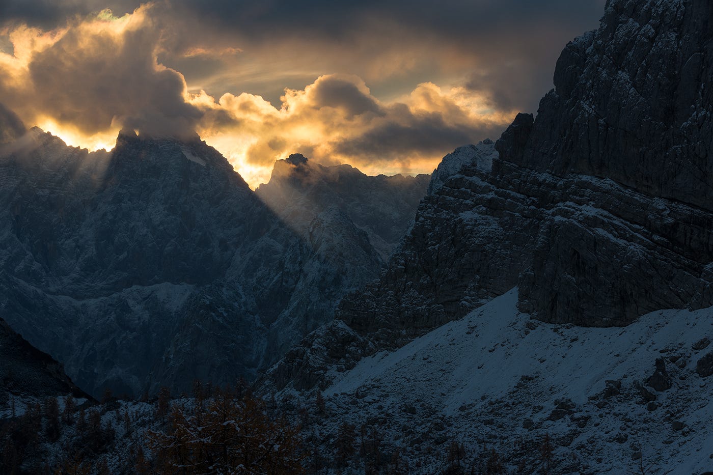 Sunlight breaking through clouds over snowy mountains HD Wallpaper