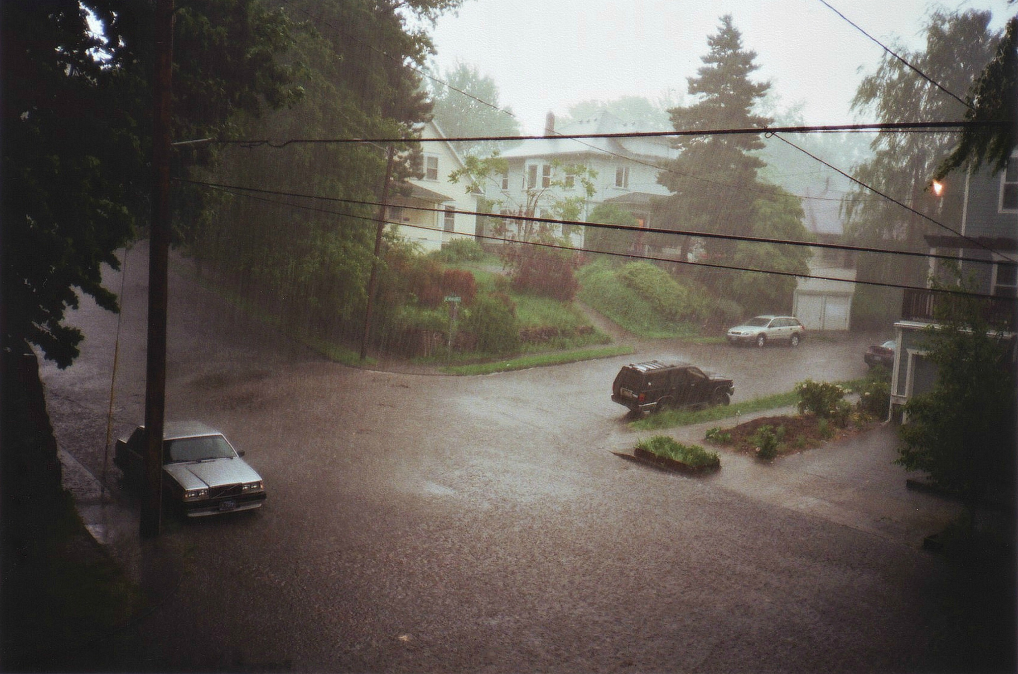 Street during heavy rain with cars and houses HD Wallpaper