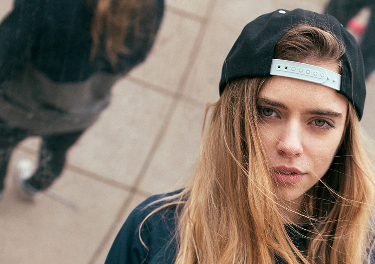 Woman wearing a black baseball cap looking at the camera HD Wallpaper