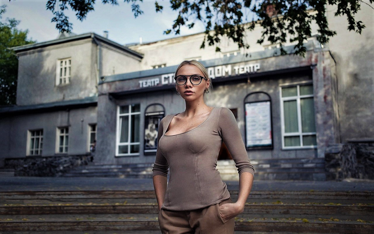 Woman with glasses in front of a theater HD Wallpaper