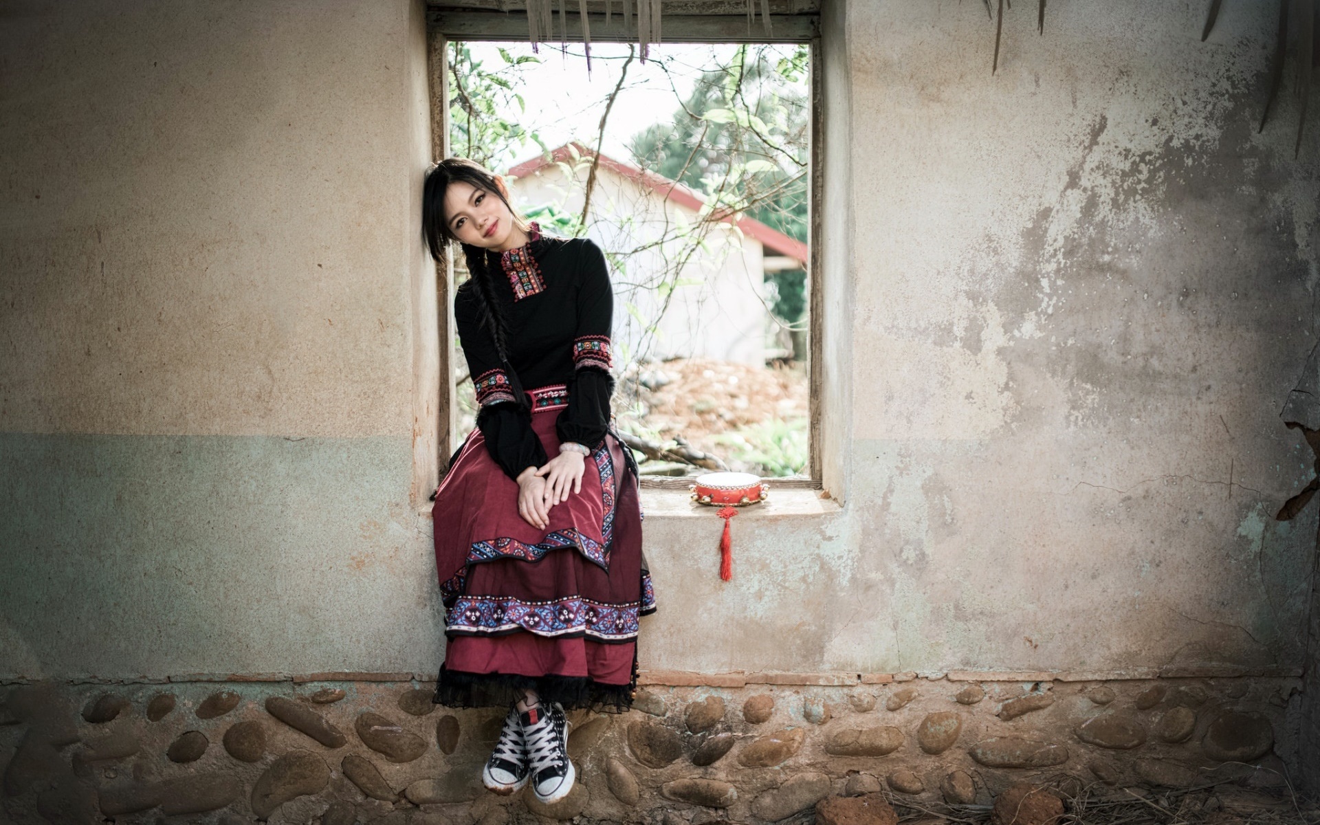Woman in traditional dress sitting by a window HD Wallpaper