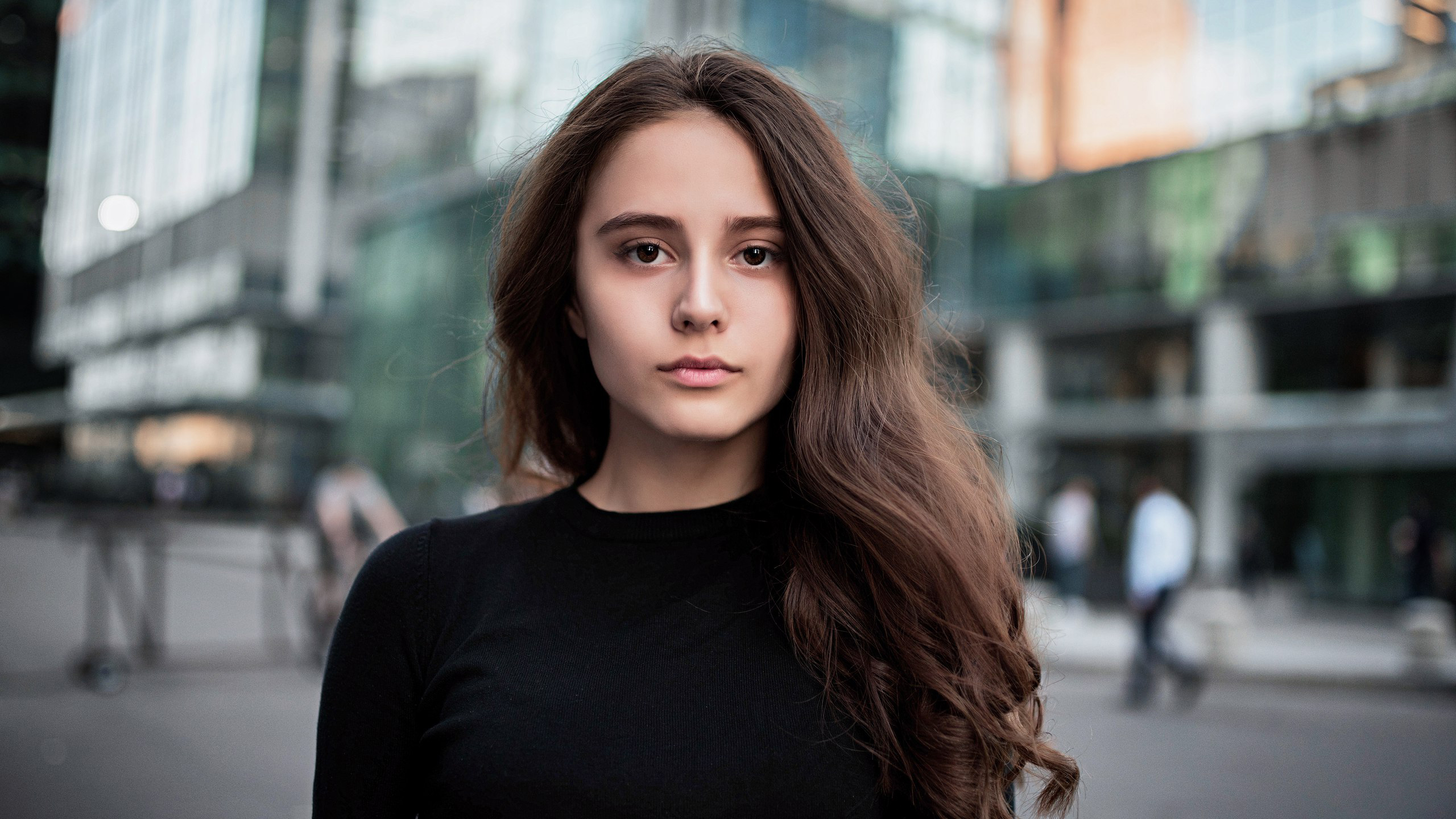 Young woman with long brown hair in a black shirt HD Wallpaper