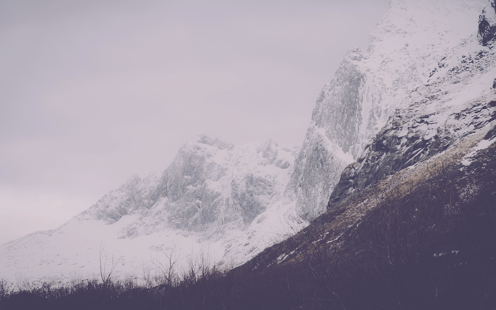 Snow-covered mountains under a cloudy sky HD Wallpaper