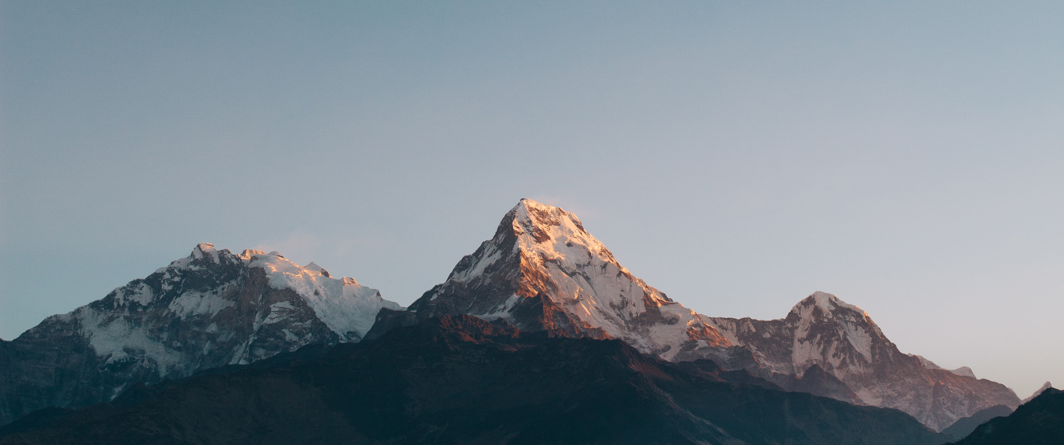 Snow-capped mountains under a clear sky HD Wallpaper
