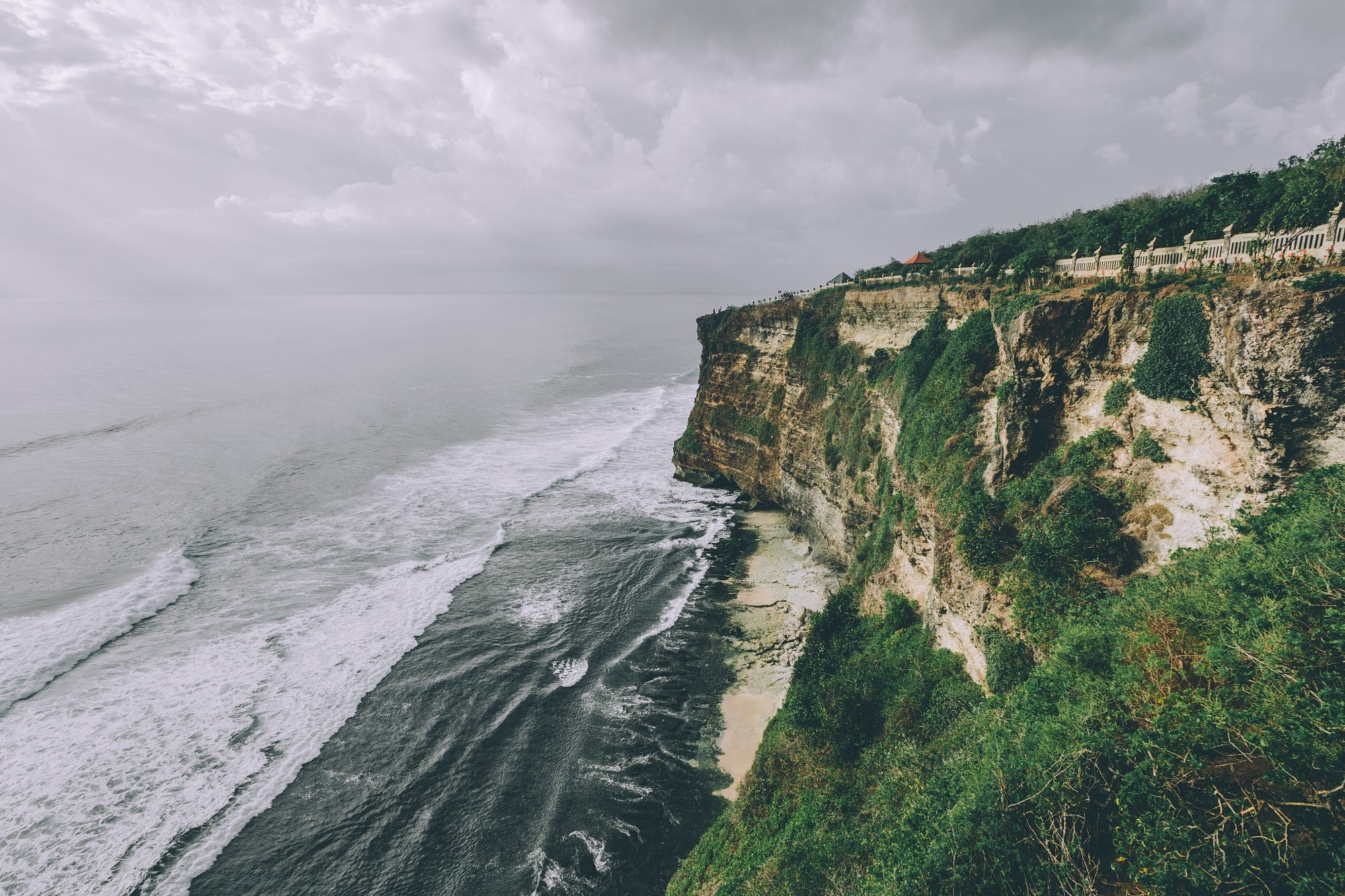 Cliff overlooking ocean with waves and cloudy sky HD Wallpaper