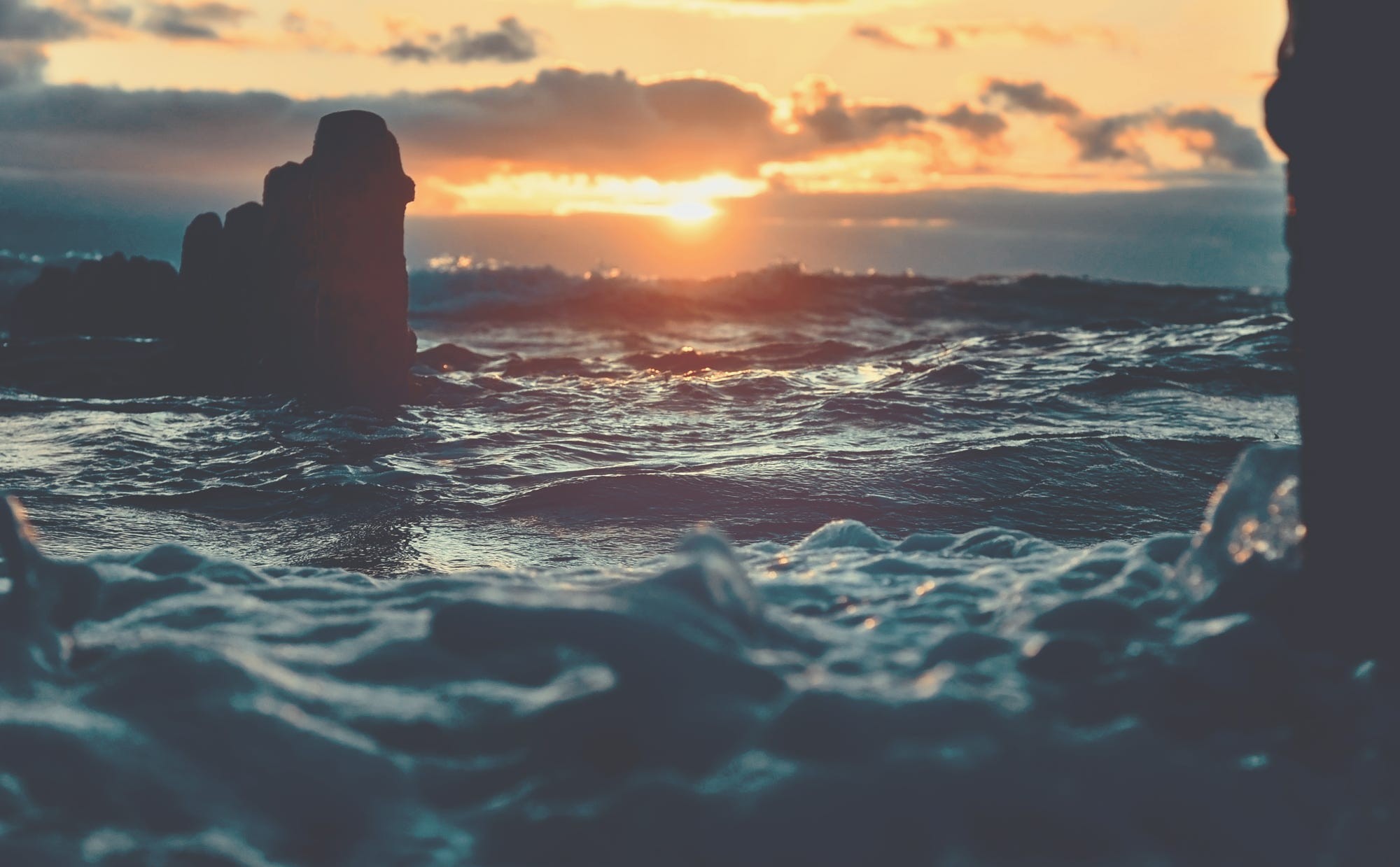 Sunset over the sea with rocks and waves HD Wallpaper