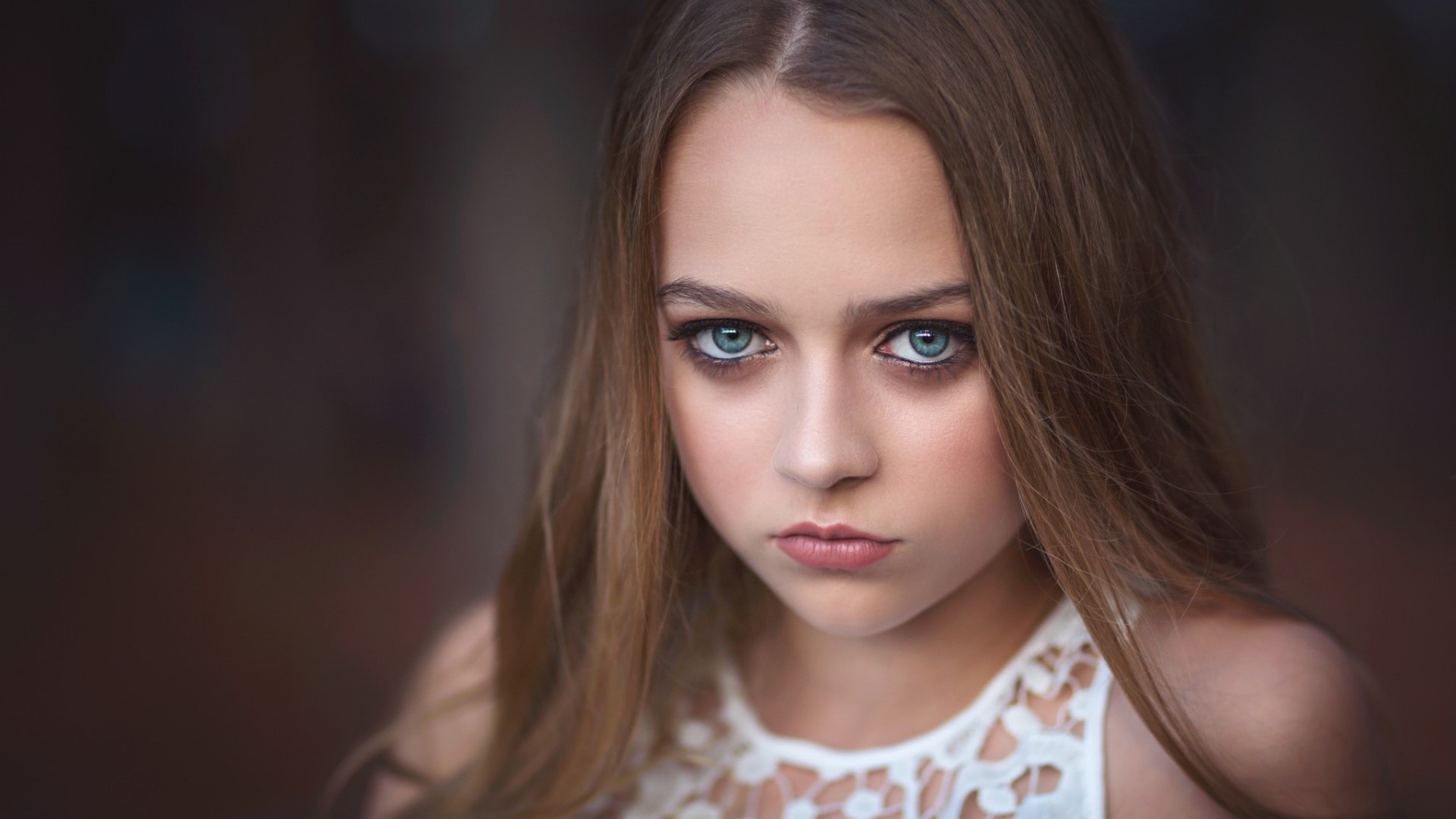 Young woman with blue eyes and long brown hair HD Wallpaper