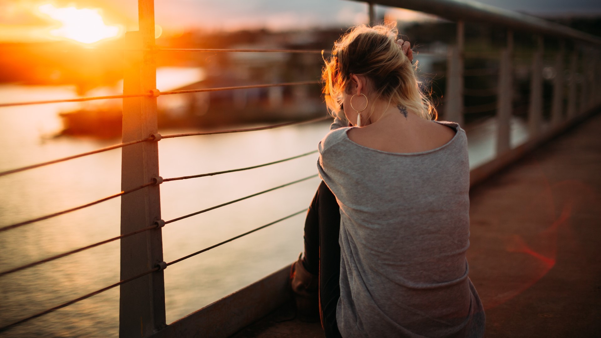 Woman sitting on a bridge at sunset HD Wallpaper