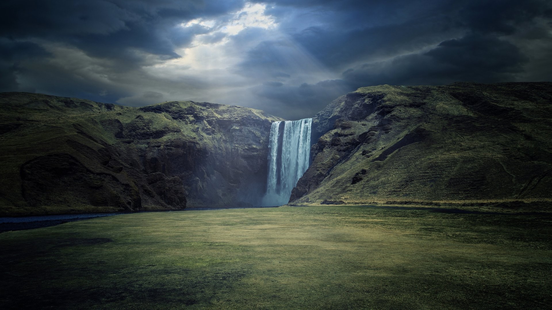 Skogafoss waterfall under dramatic clouds HD Wallpaper