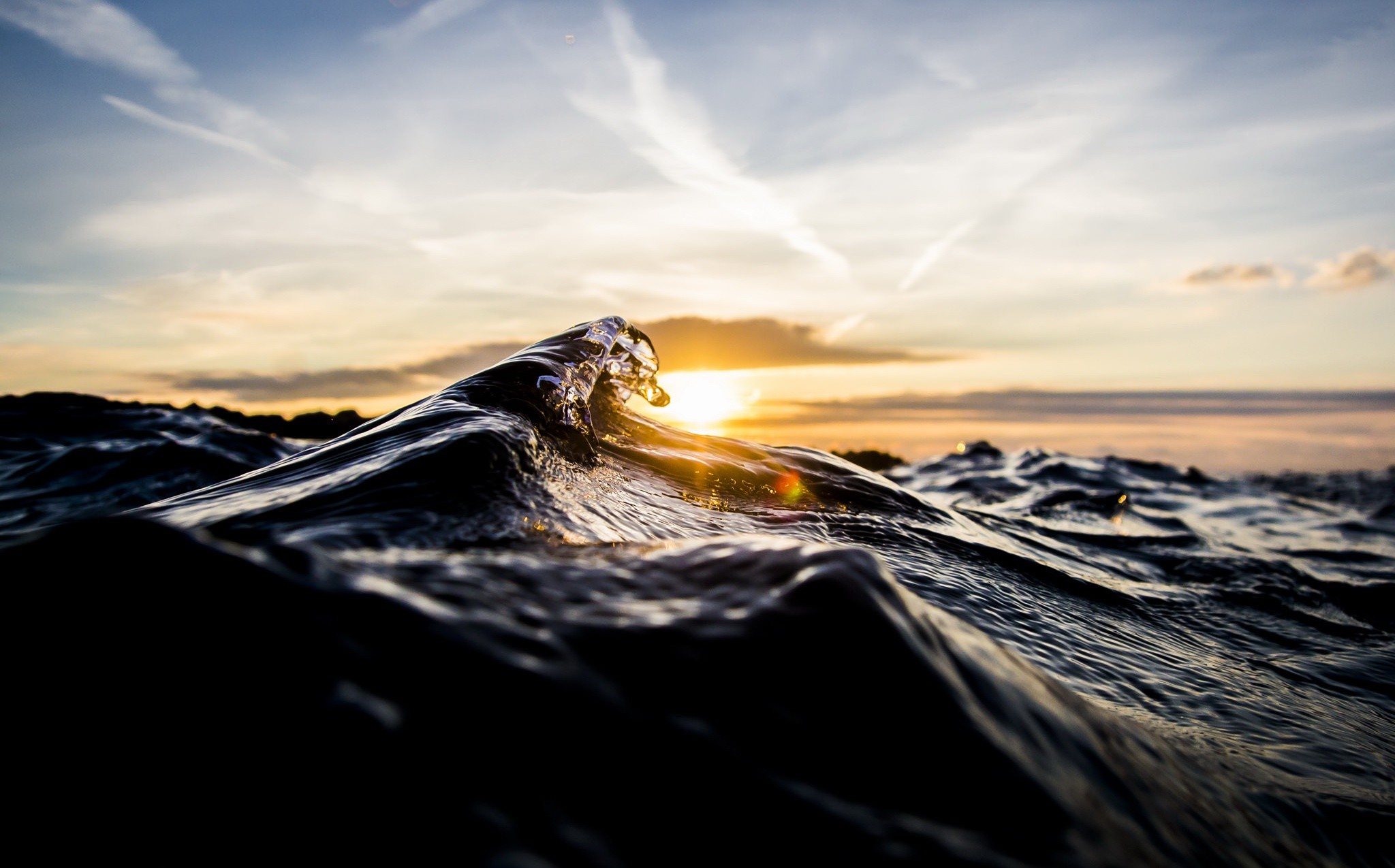 Wave cresting at sunset over the sea HD Wallpaper
