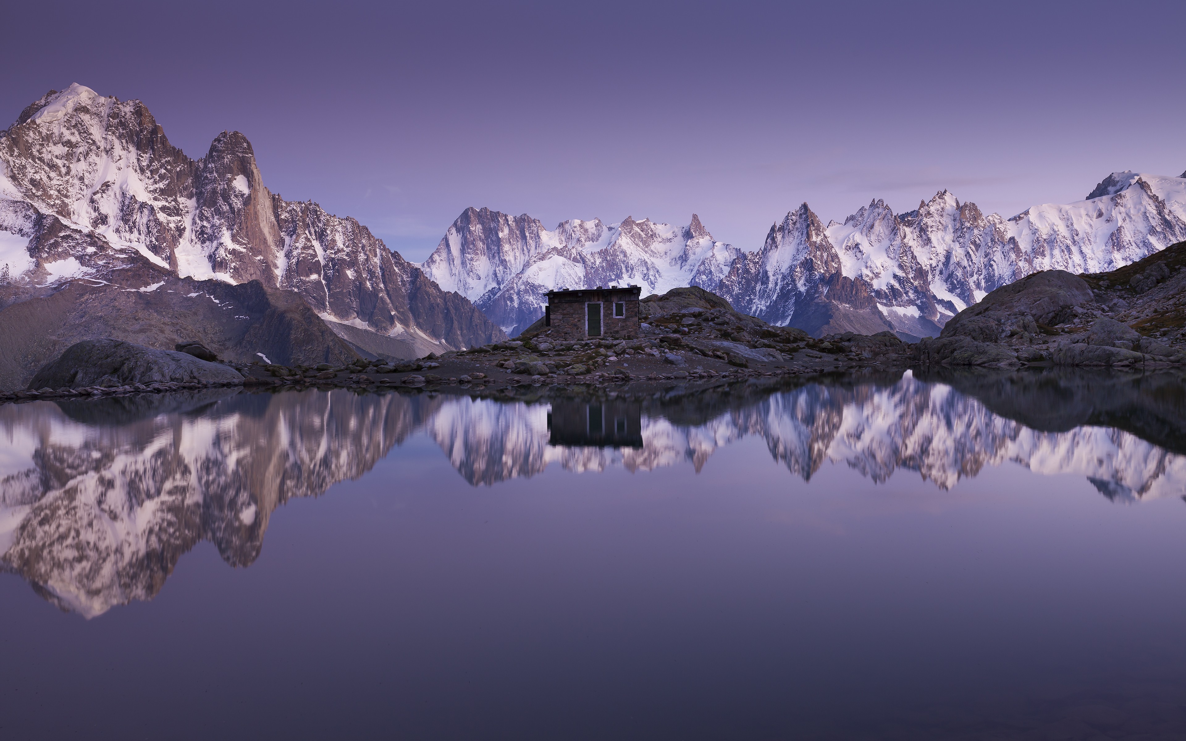 Mountain range reflected in a lake at sunset HD Wallpaper
