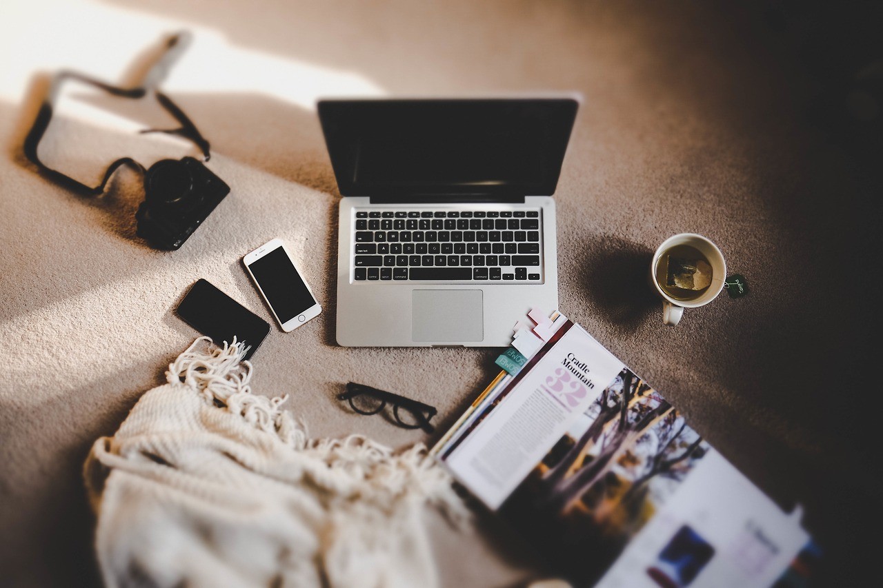 Laptop, camera, phones, glasses, and magazine on carpet HD Wallpaper