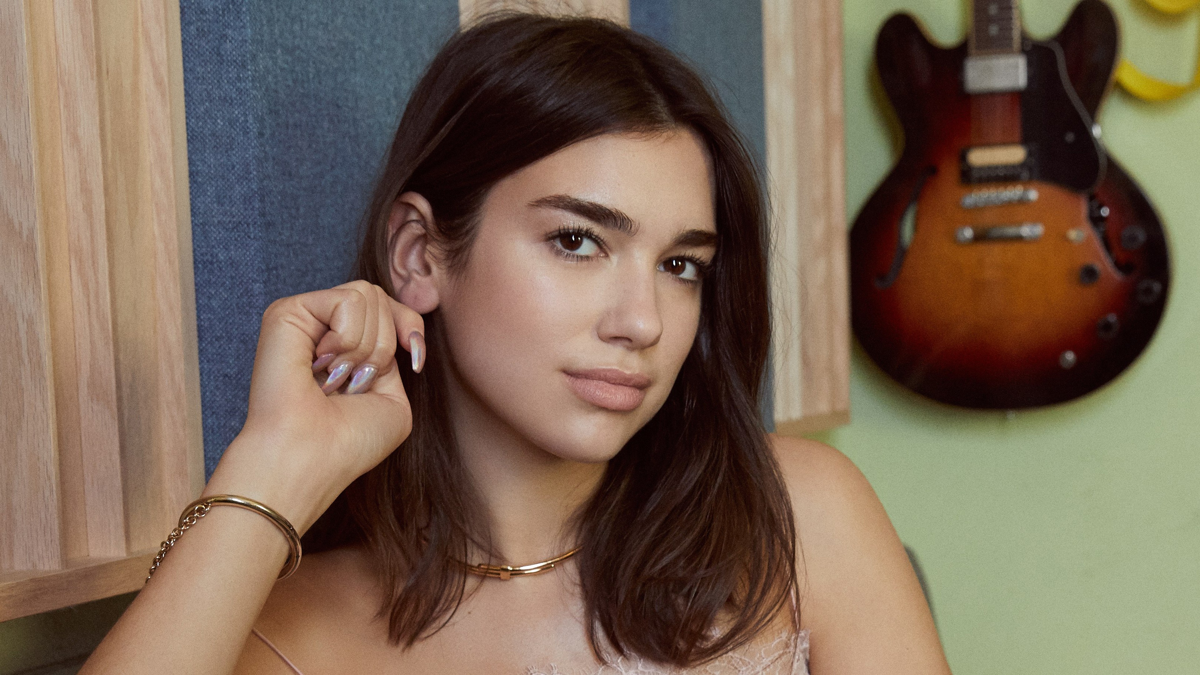 Dua Lipa posing with a guitar in the background HD Wallpaper