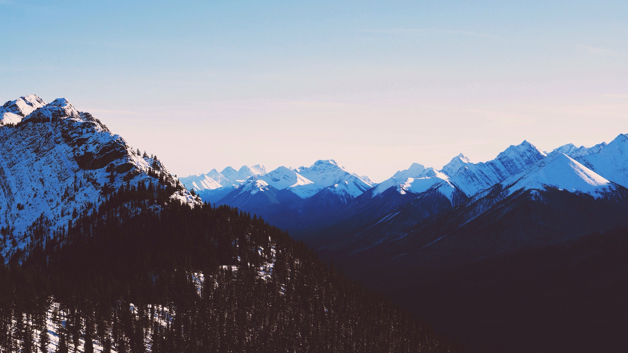 Snow-capped mountains under a clear sky HD Wallpaper