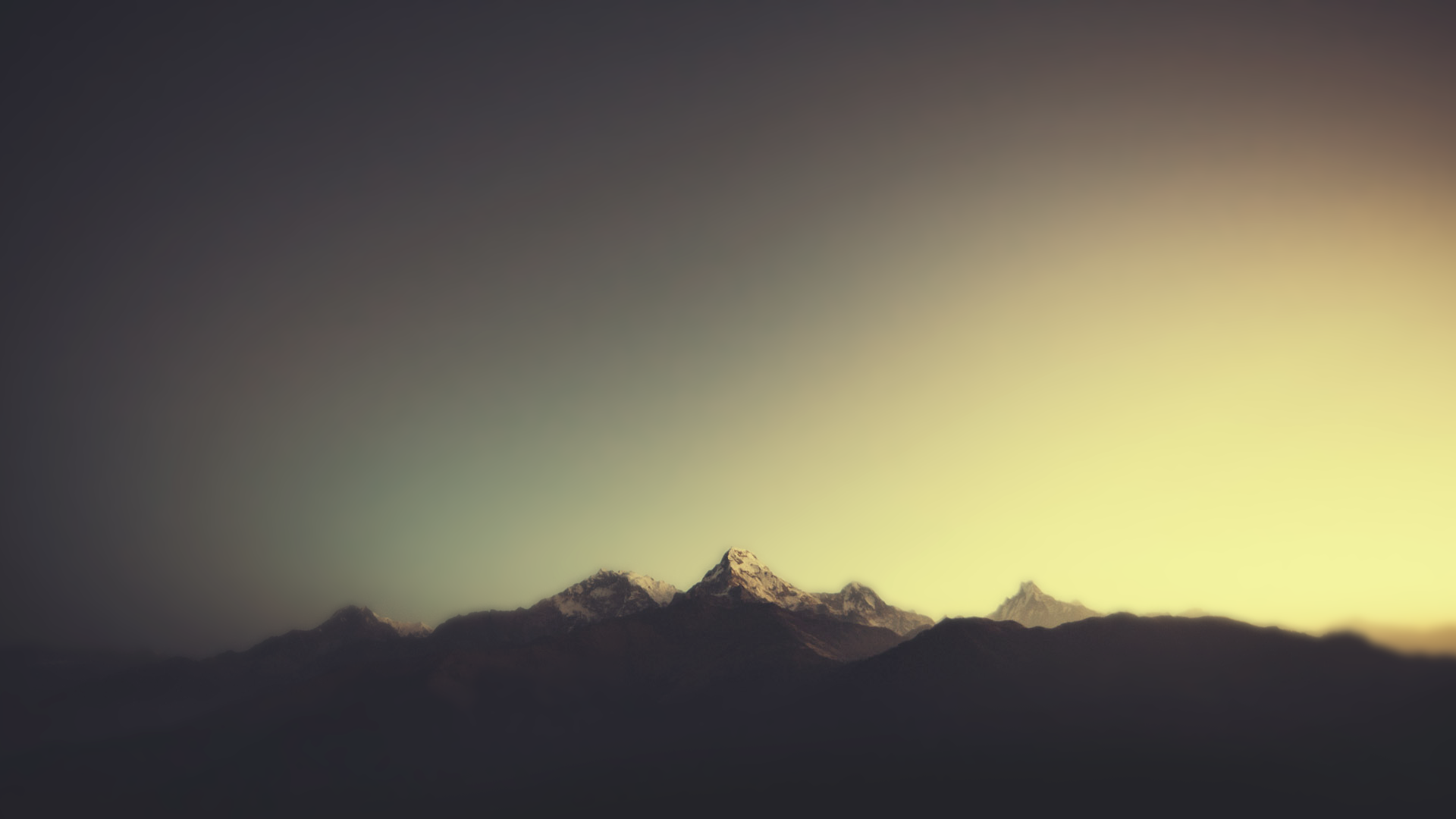 Snow-capped mountains at sunset with atmospheric lighting HD Wallpaper