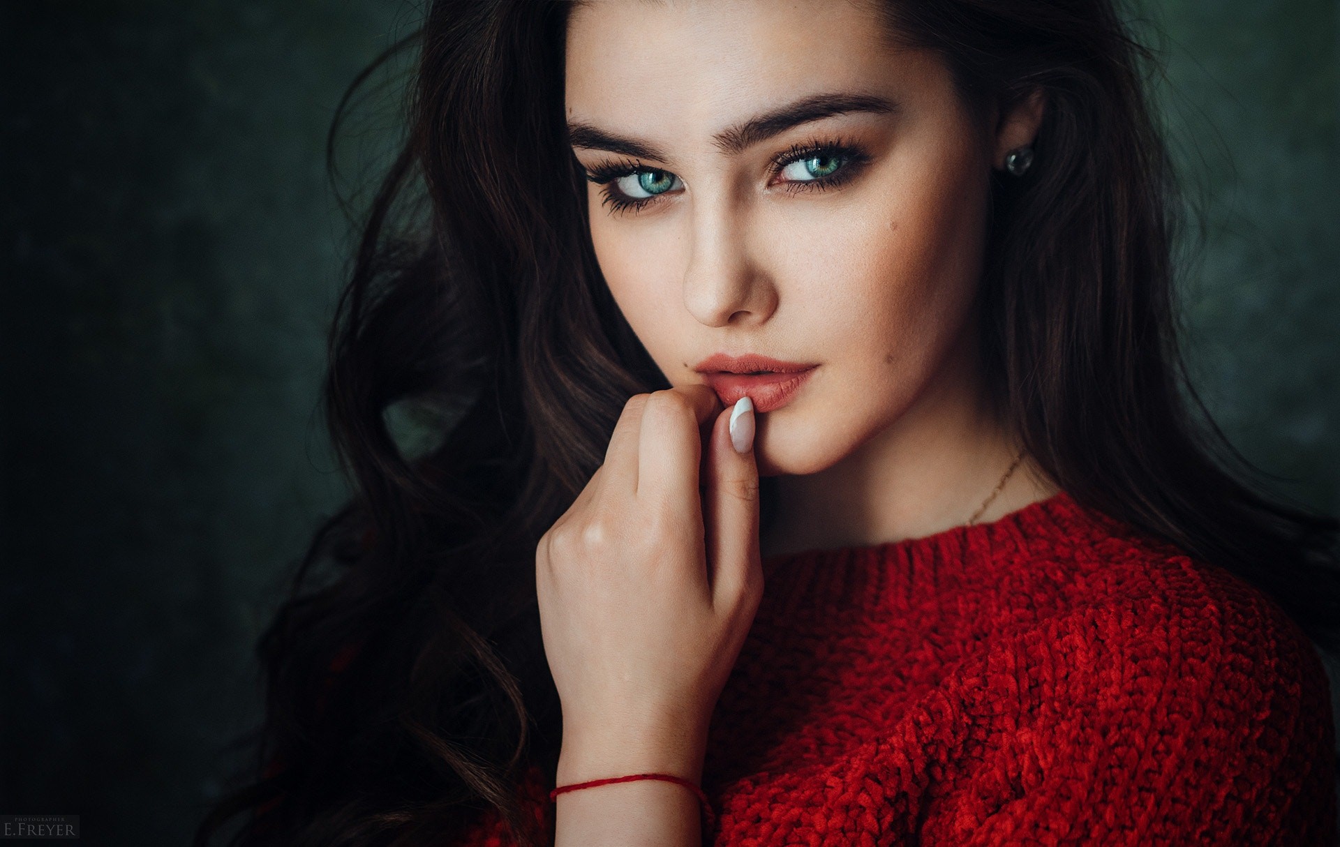 Woman with green eyes and finger on lips HD Wallpaper
